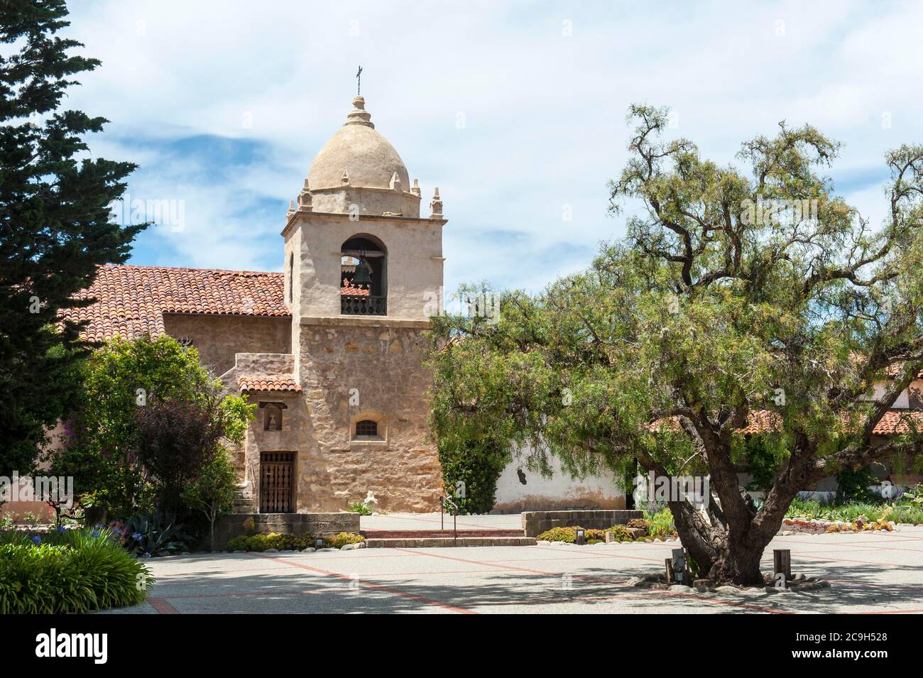 Katholische Kirche, alte spanische Mission, Mission San Carlos Borromeo de Carmelo, Kirchturm, Baum im Hof, Carmel-by-the-Sea, Kalifornien, USA Stockfoto