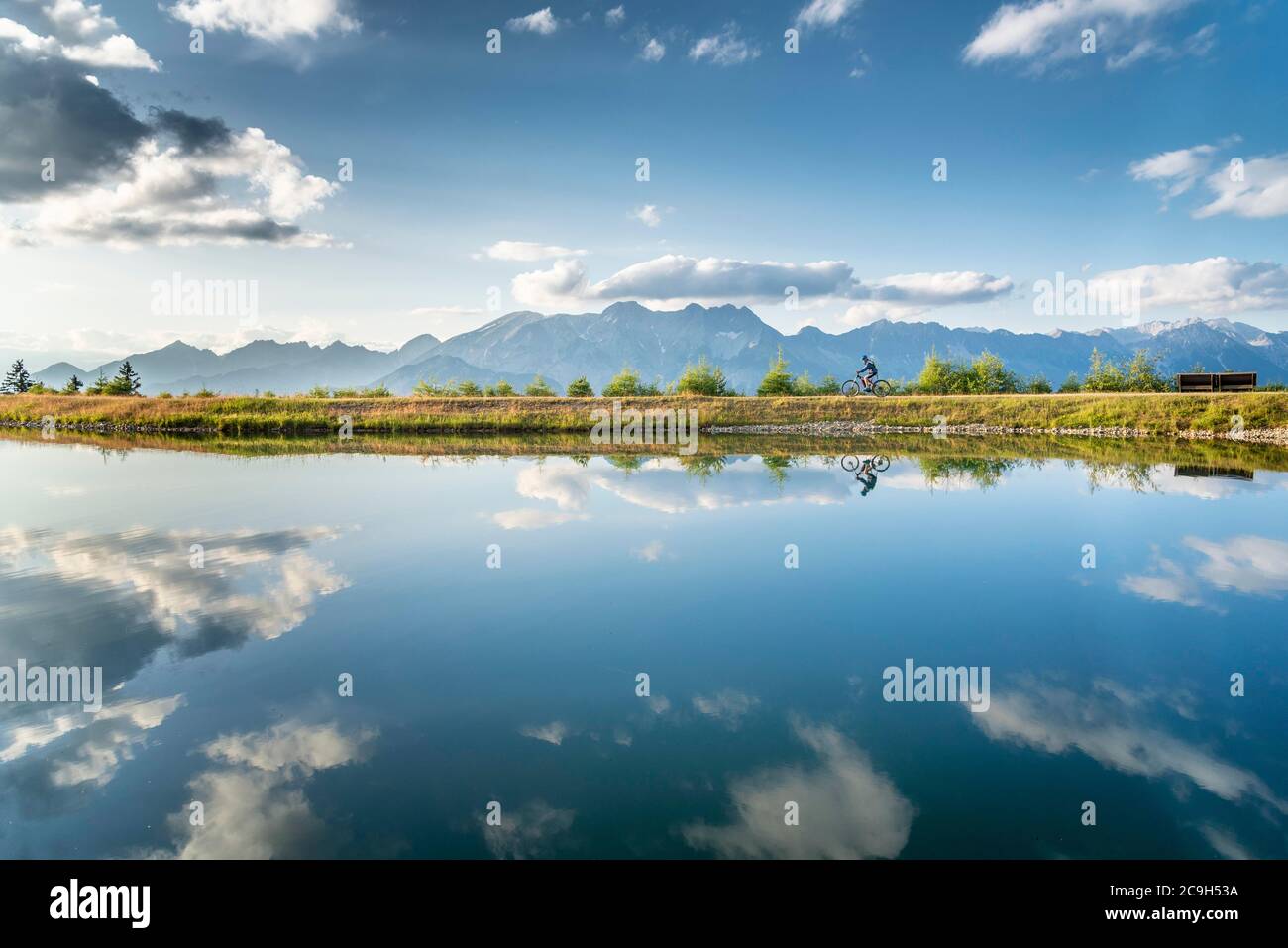 Mountainbiker mit E-Bike am Seeufer vor einer Bergkulisse, Mutterer Alm, Stubaier Alpen, Mutters, Tirol, Österreich Stockfoto