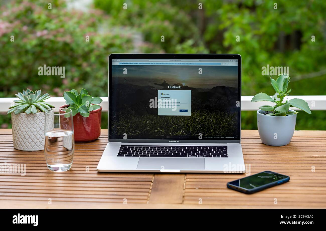 Home Office mit Laptop, Apple MacBook Pro mit iPhone X am Schreibtisch, mit offenem E-Mail-Programm Microsoft Outlook, Deutschland Stockfoto