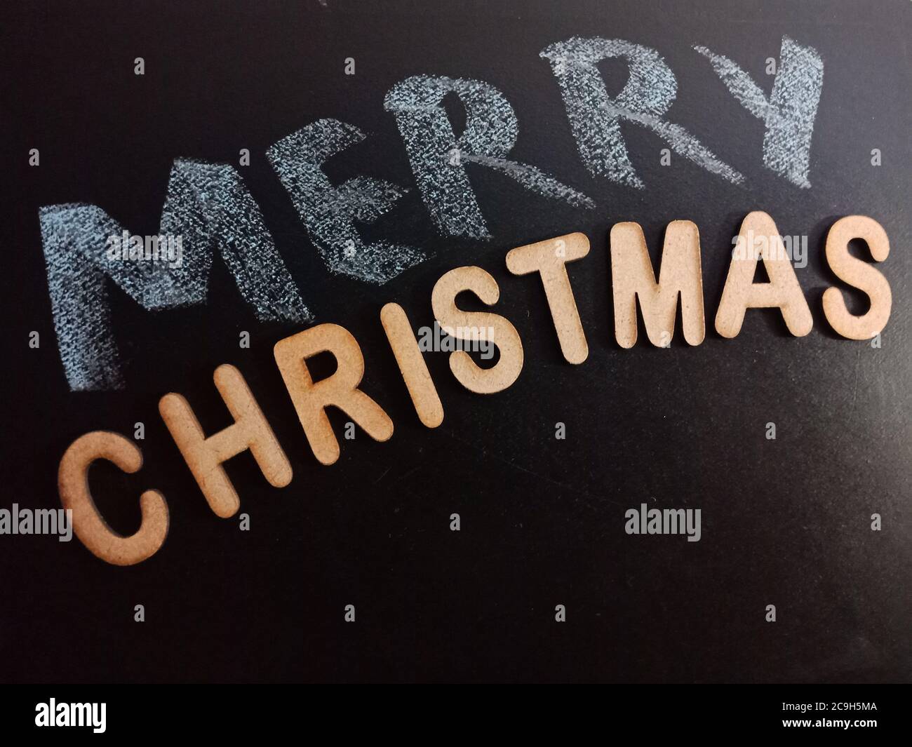 frohe Weihnachten Wort präsentiert mit Holzbuchstaben Kunst auf Kreidetafel Textkonzept. Stockfoto