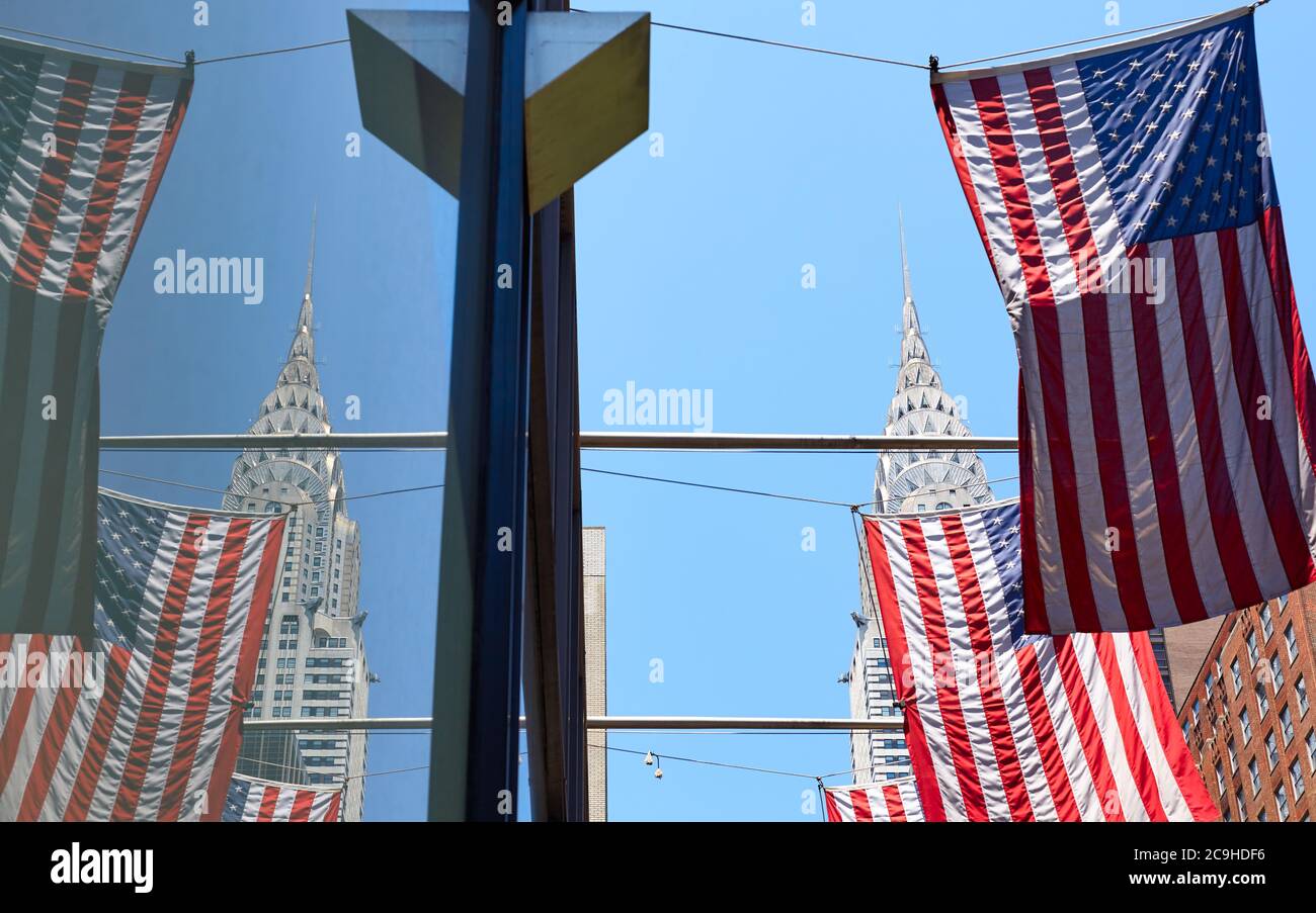 New York, 30. Juni 2018: Chrysler Building Krone reflektiert in Fenster durch American Flags gesehen, Fokus auf die Krone. Stockfoto