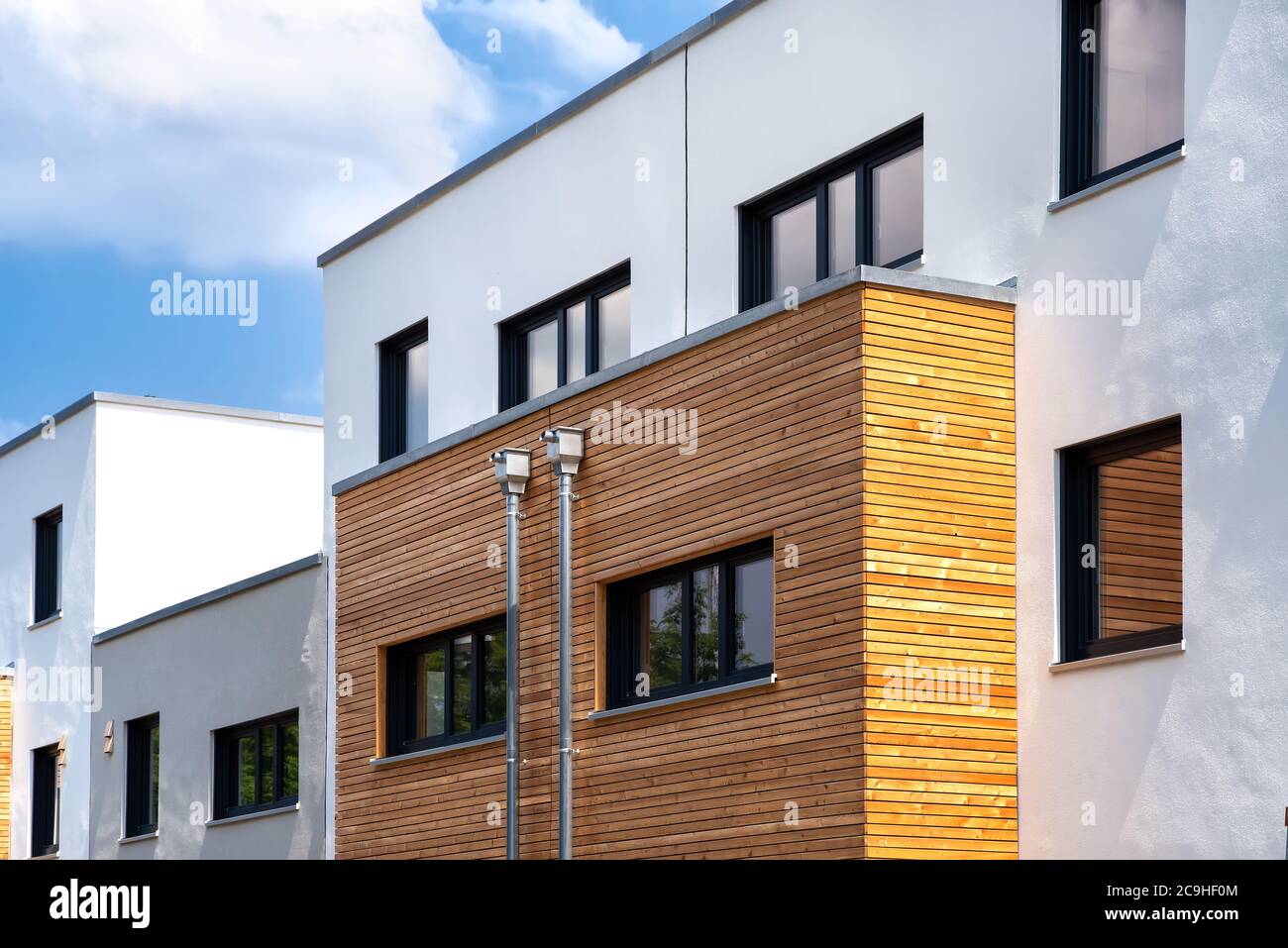 Weiße Gebäudefassade mit Holzpaneelen und Gips Stockfoto