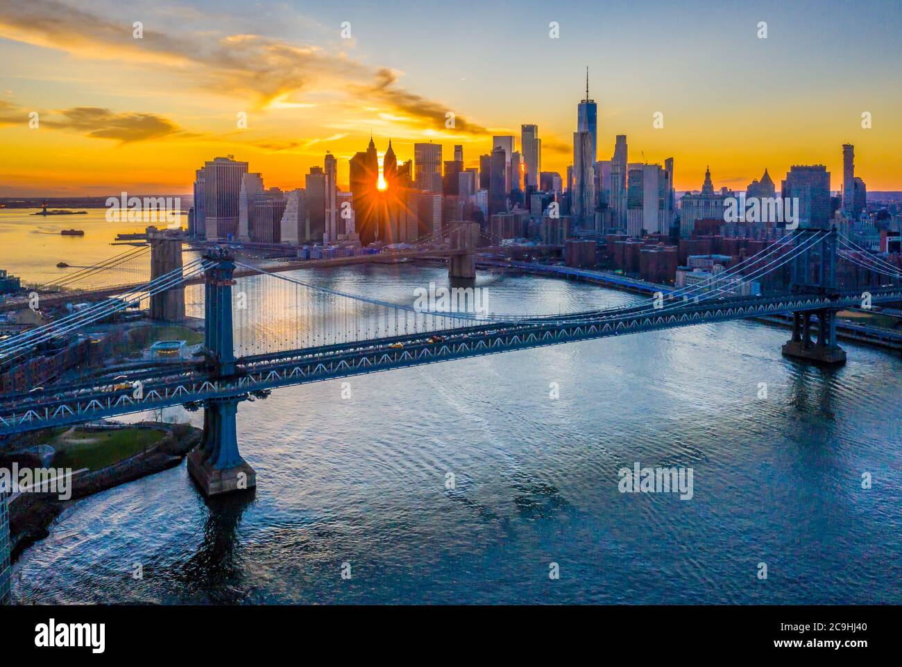 Luftaufnahme der Brooklyn und Manhattan Brücken bei Sonnenuntergang mit der Lower Manhattan Skyline entlang des East River, Brooklyn Bridge Park Stockfoto