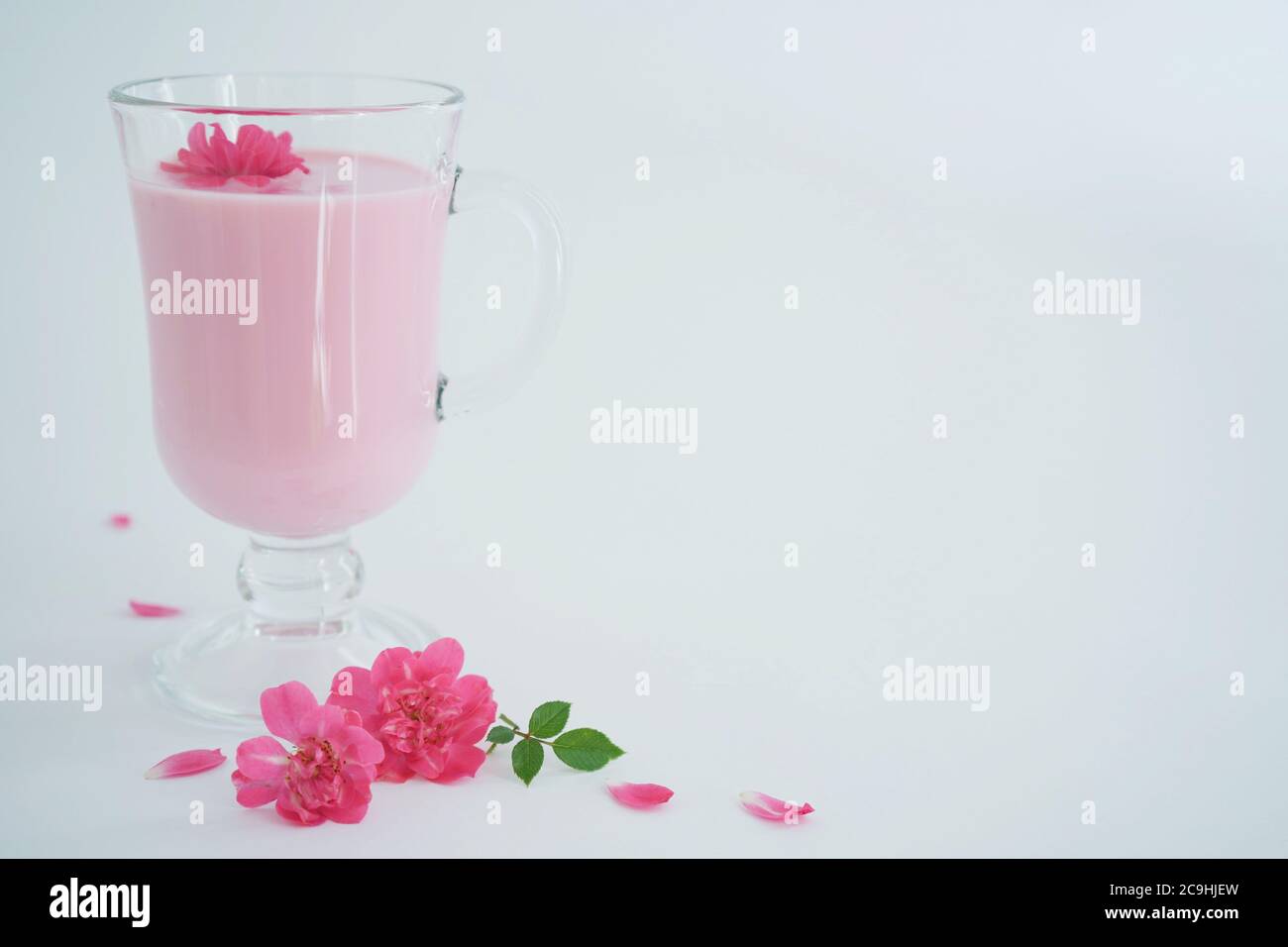 Rosenmondmilch für einen besseren Schlaf mit Kopierplatz. Ayurveda warmes Getränk verbraucht vor dem Bett. Schön im Falle von Schlaflosigkeit. Weißer Hintergrund, Nahaufnahme. Stockfoto