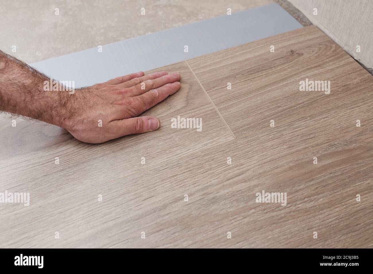 Schritt-für-Schritt-Anleitung zum Verlegen von Laminatböden - Verbinden von Lamellen mit Quer- und Längsverriegelung Stockfoto