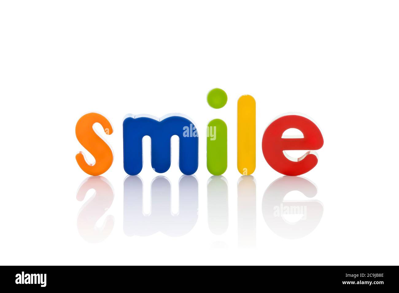 Das Wort 'Smile' in bunten Buchstaben vor weißem Hintergrund. Stockfoto