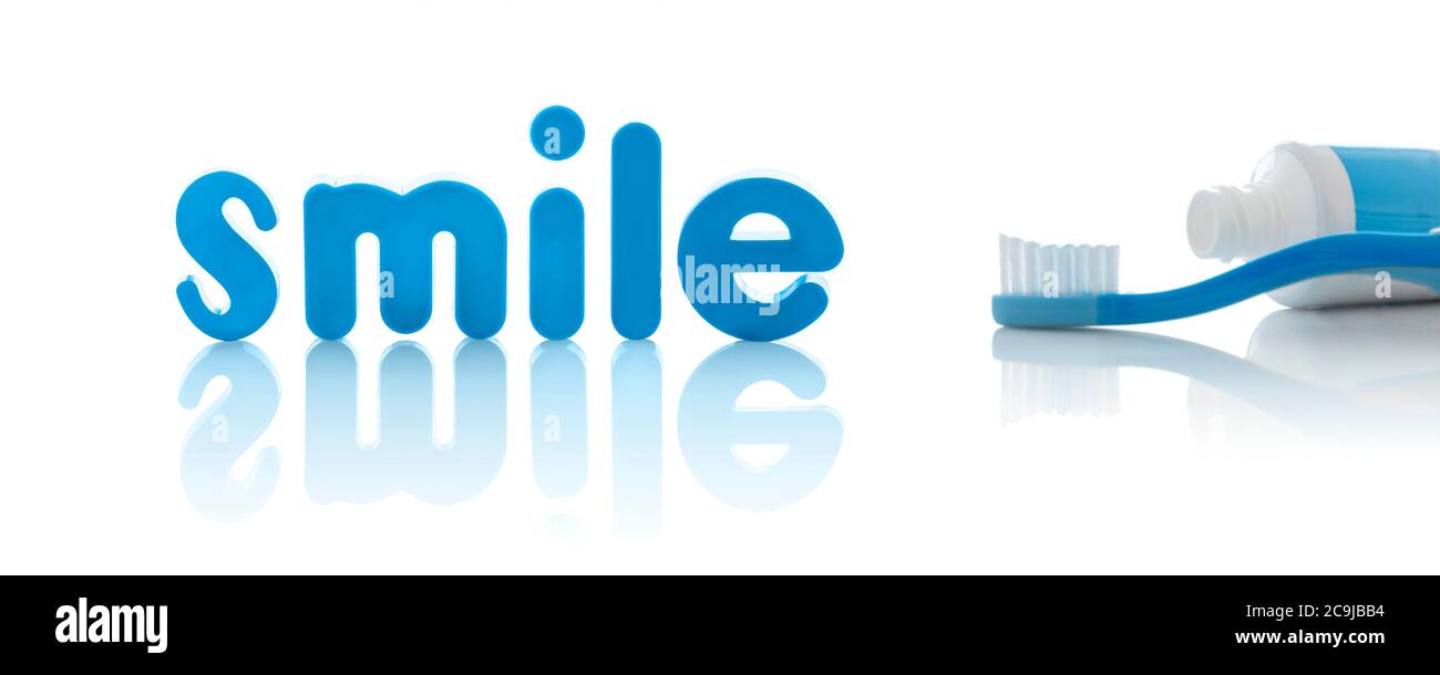 Das Wort 'Smile' in blauen Buchstaben mit Zahnbürste, vor weißem Hintergrund. Stockfoto