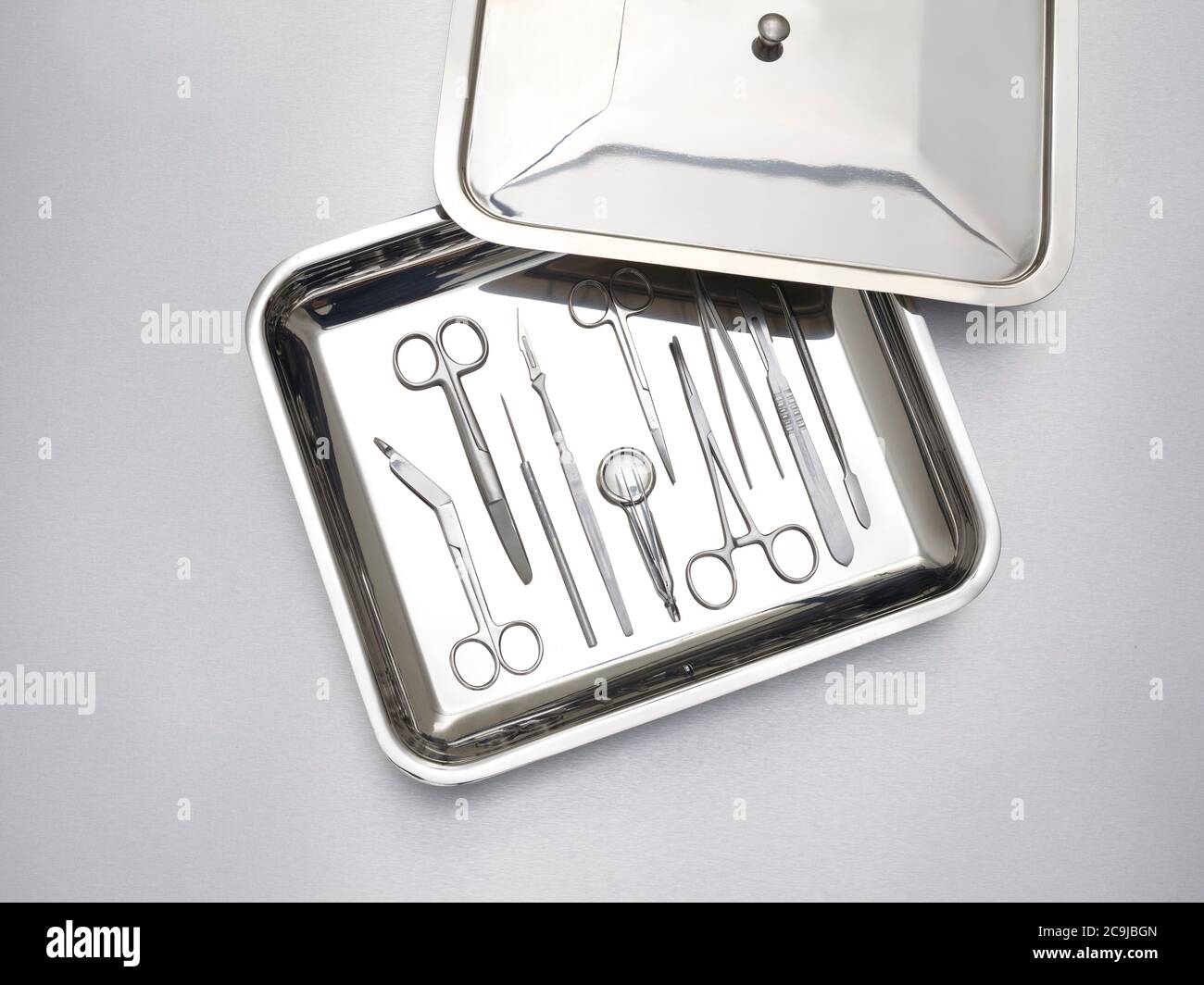 Chirurgische Ausrüstung in einem Tablett vor grauem Hintergrund. Stockfoto