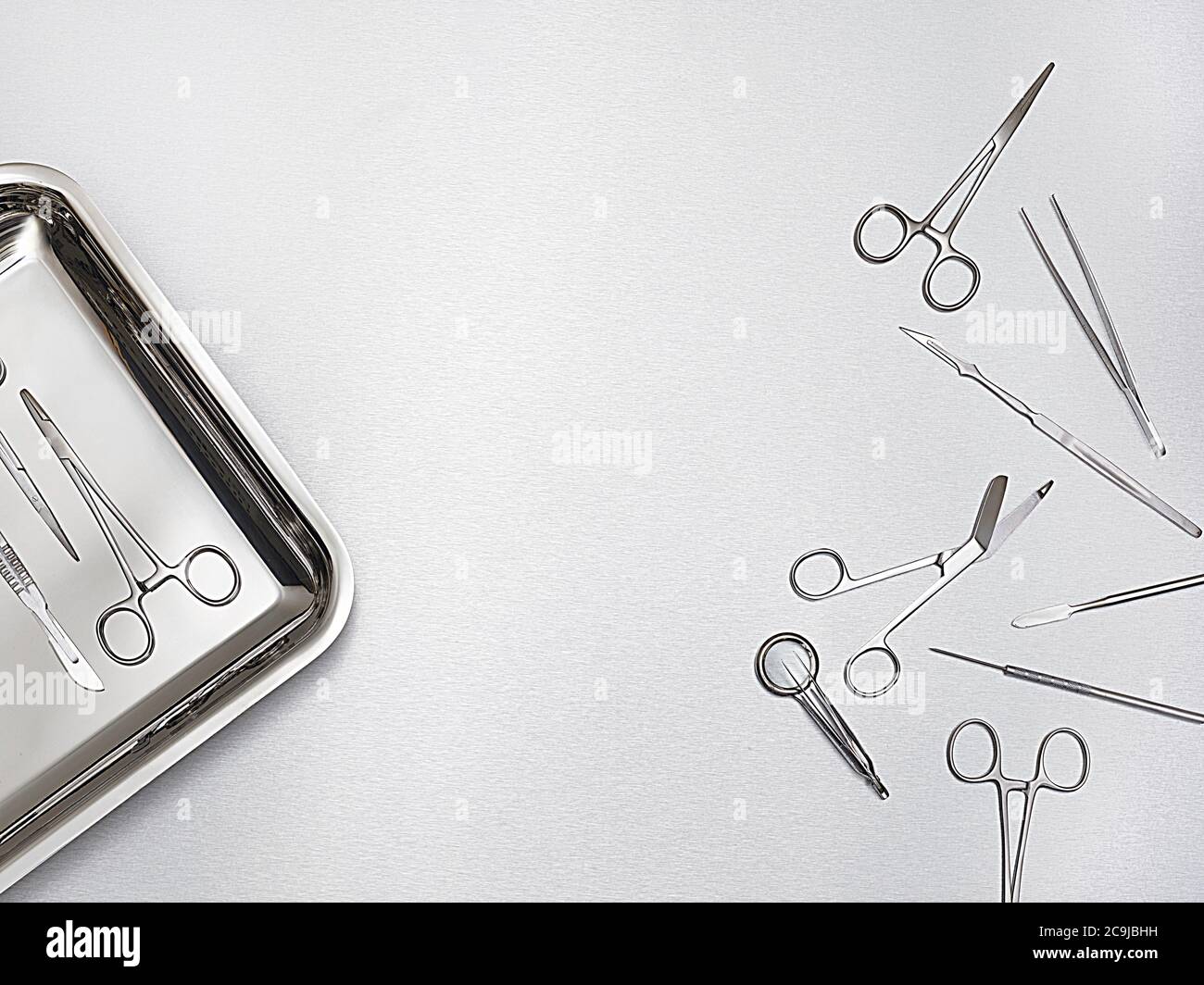 Chirurgische Schere und Tablett vor einem grauen Hintergrund. Stockfoto