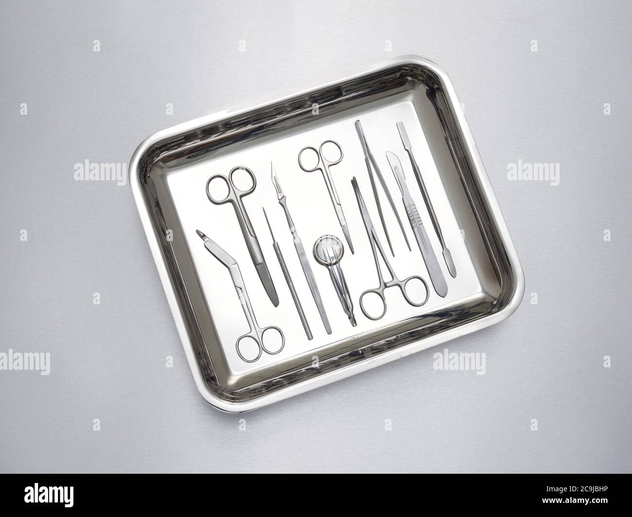 Chirurgische Ausrüstung in einem Tablett vor grauem Hintergrund. Stockfoto