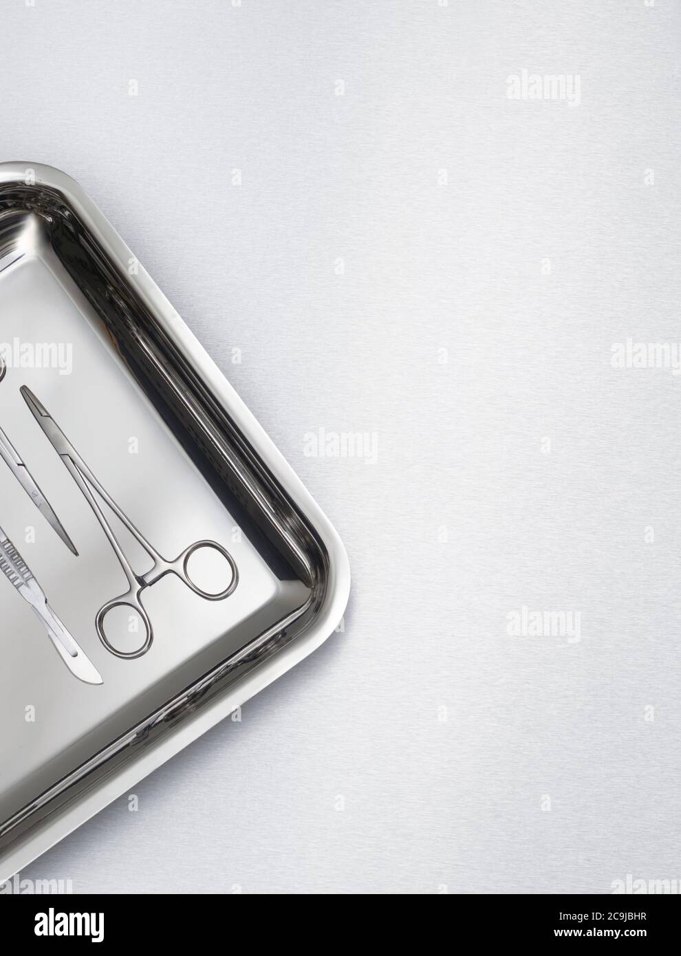 Chirurgische Schere auf einem Tablett vor grauem Hintergrund. Stockfoto