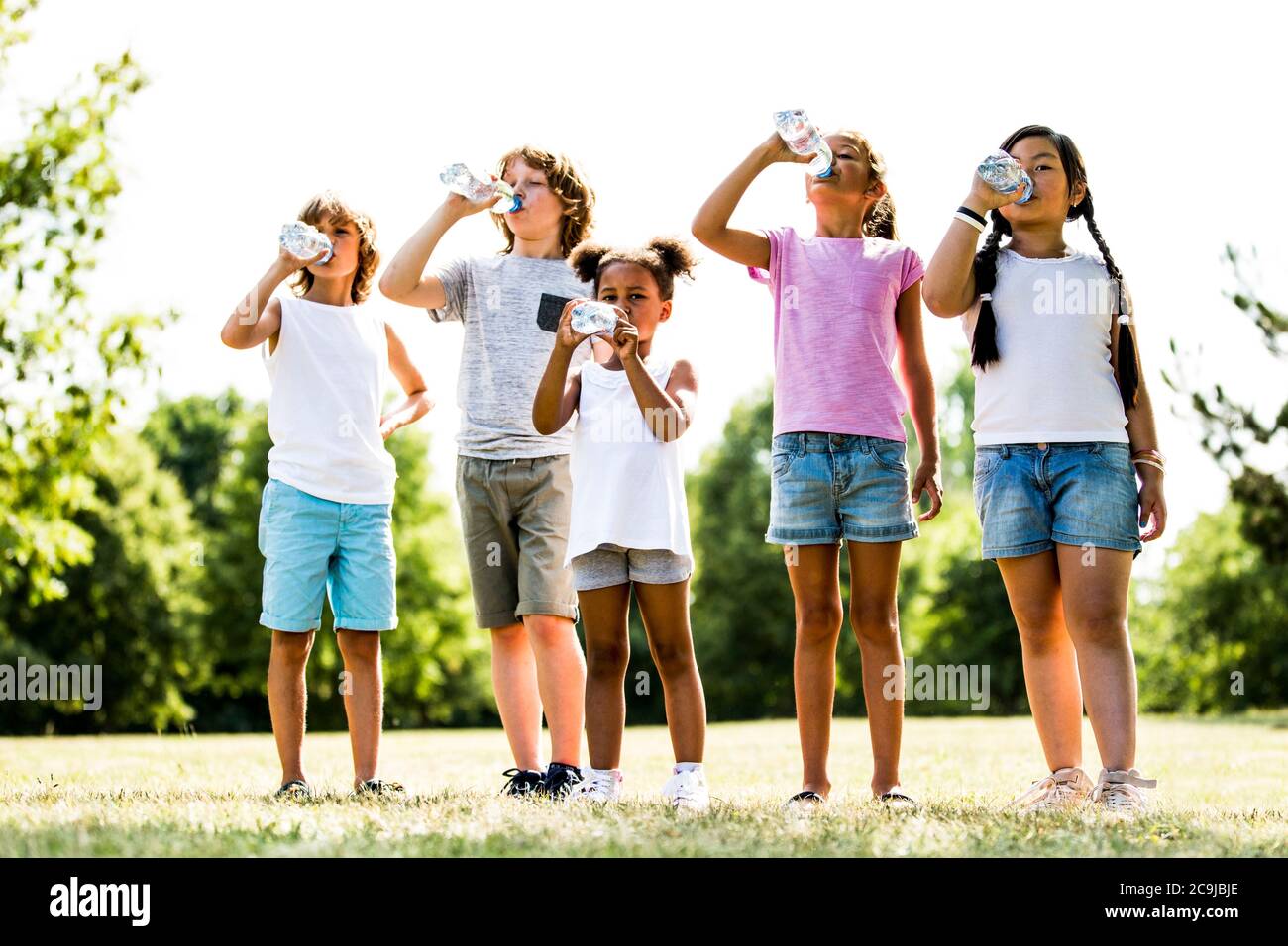 Kinder trinken Wasser im Park. Stockfoto