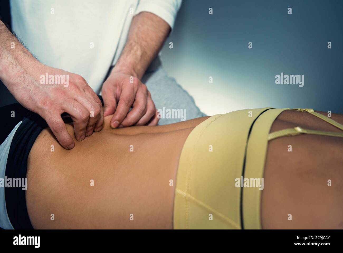Myofasziale Freisetzung. Praktizierender, der auf dem Rücken des Patienten arbeitet. Stockfoto