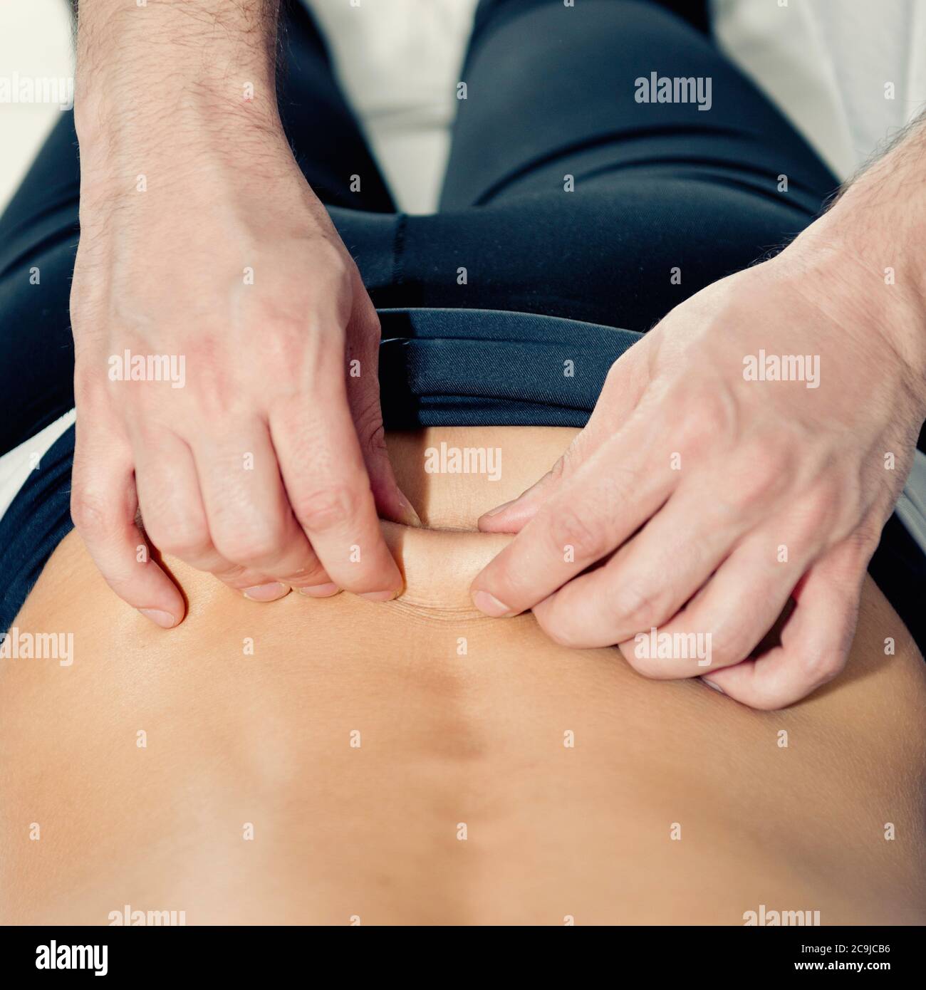 Myofasziale Freisetzung. Praktizierender, der auf dem Rücken des Patienten arbeitet. Stockfoto