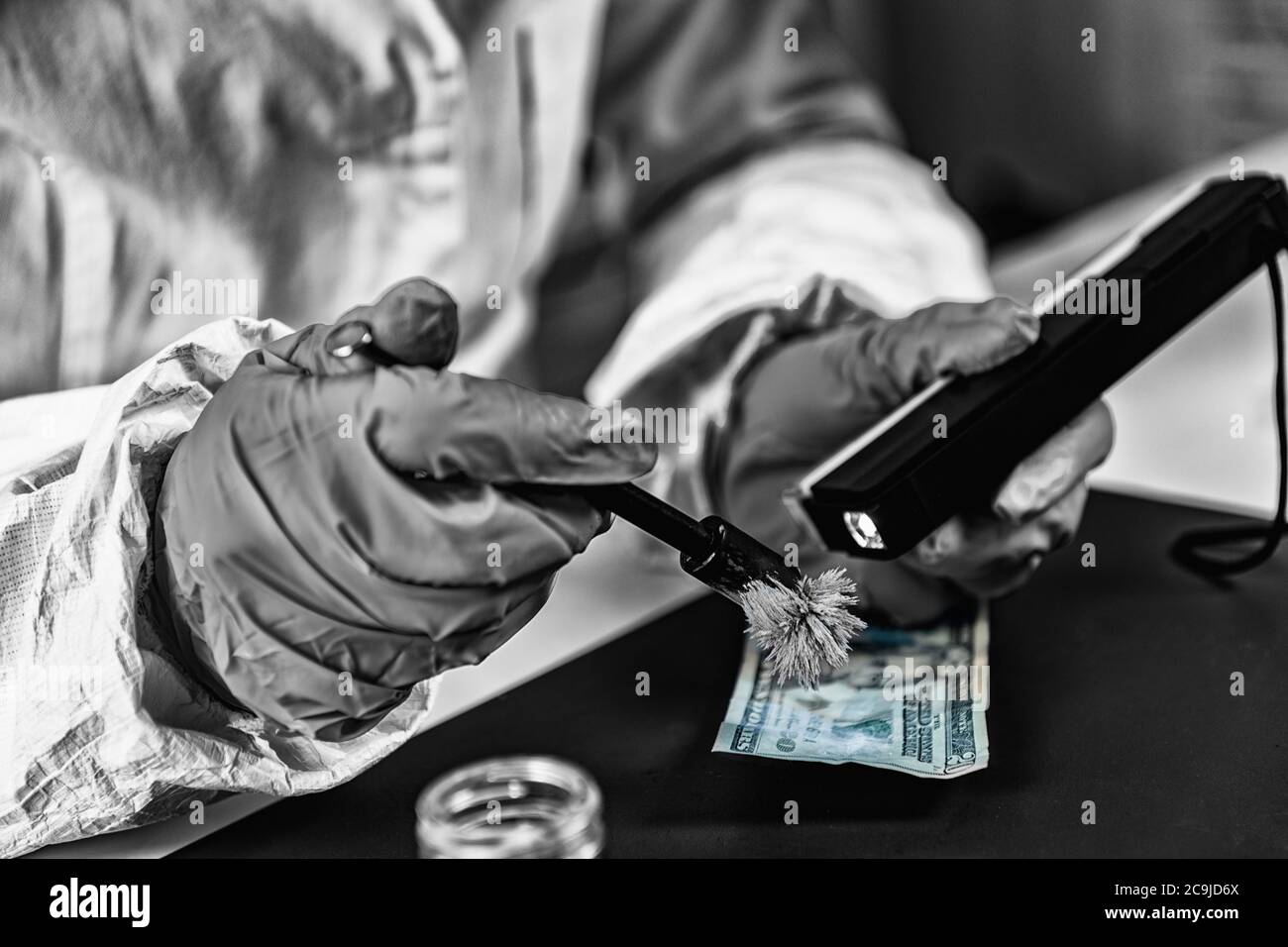 Forensisches Labor. Polizeiexperte untersucht Banknote, auf der Suche nach Fingerabdrücken. Stockfoto
