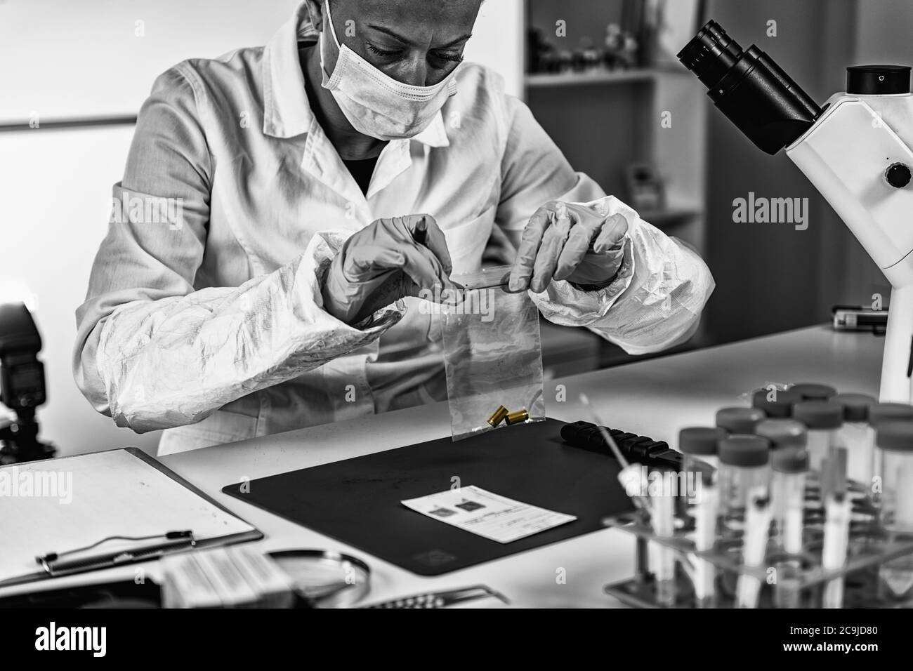Forensische Wissenschaft im Labor. Forensischer Techniker, der das Geschossgehäuse untersucht. Stockfoto