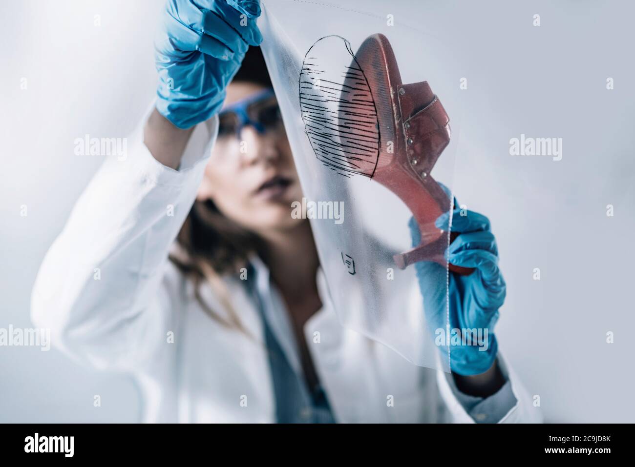 Forensische Wissenschaft im Labor. Forensischer Wissenschaftler, der Schuh auf Beweise untersucht. Stockfoto