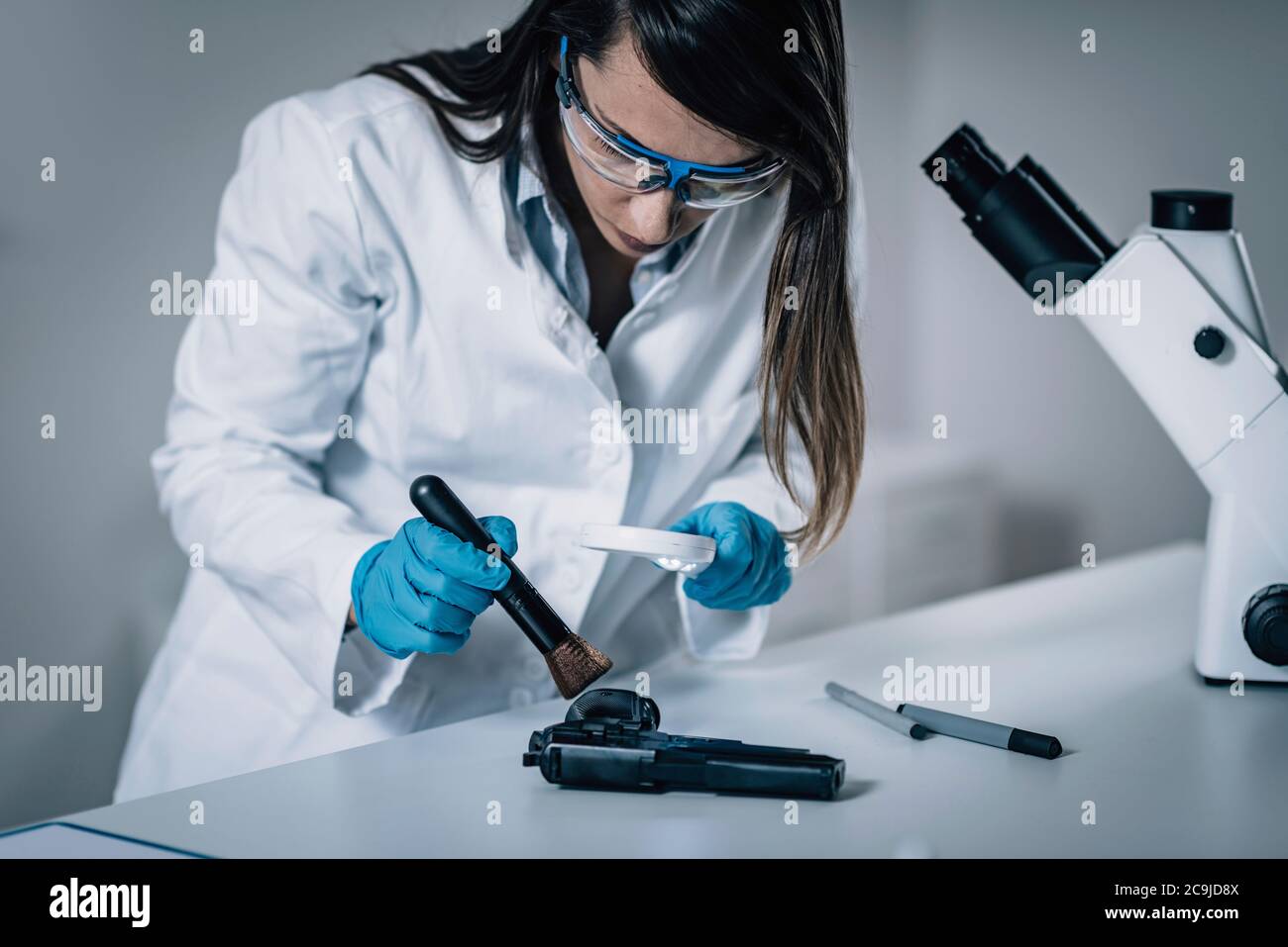 Forensische Wissenschaft im Labor. Forensischer Wissenschaftler, der die Waffe auf Beweise untersucht. Stockfoto