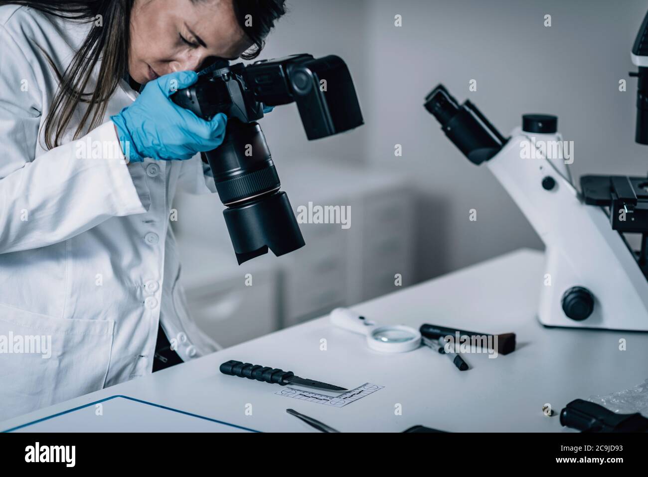 Forensische Wissenschaft im Labor. Forensischer Wissenschaftler fotografiert Messer mit Blut Beweise. Stockfoto