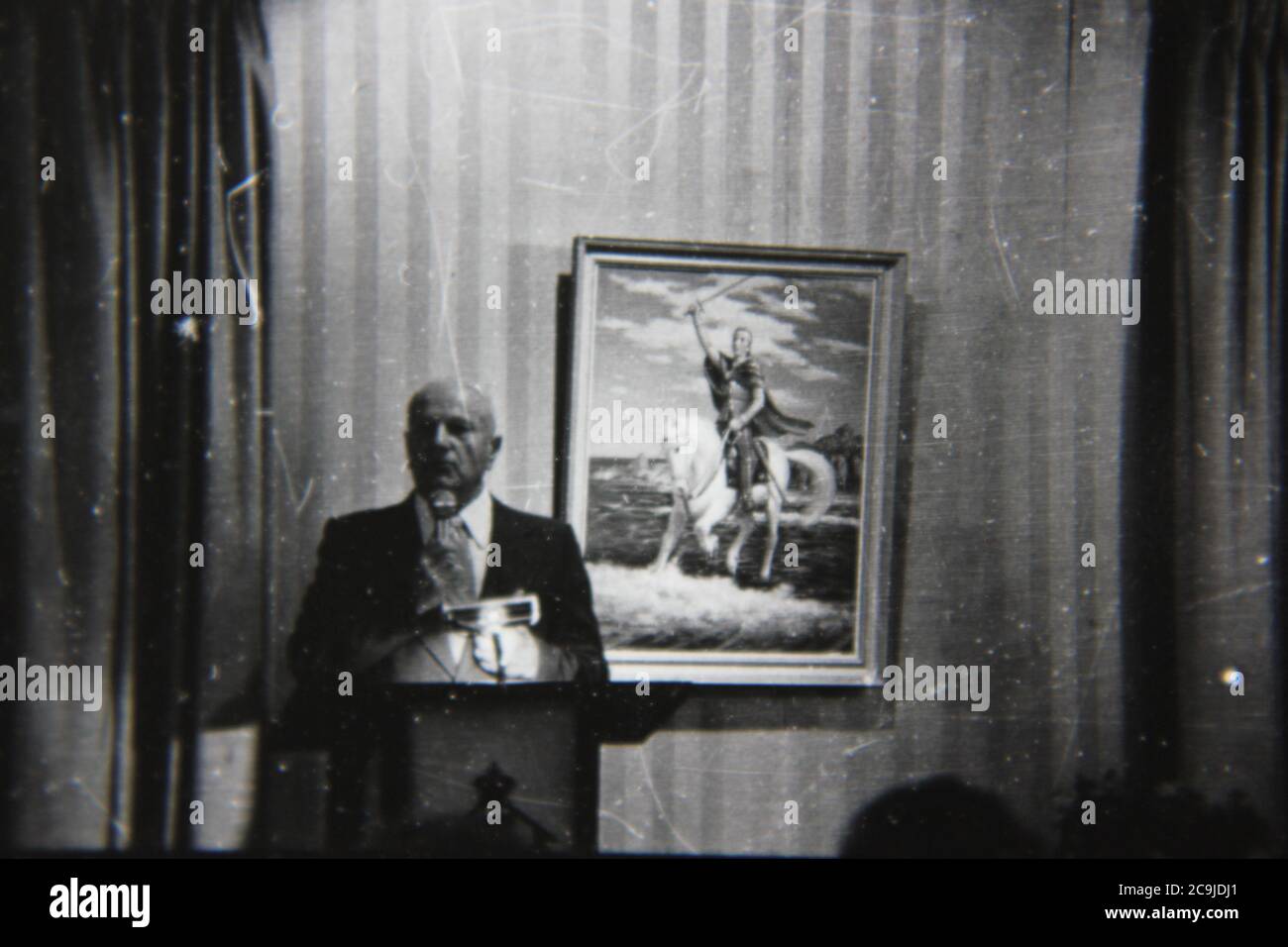 Feine Vintage-Schwarz-Weiß-Fotografie eines erwachsenen Sprechers aus den 1970er Jahren, der auf dem Podium referiert. Stockfoto
