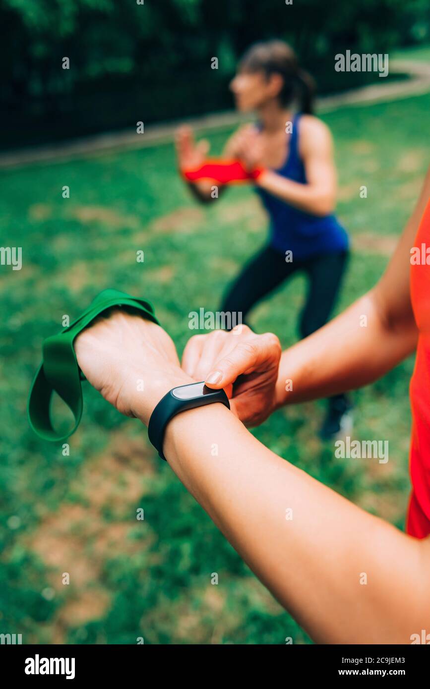 Frau überprüft den Fortschritt auf der Smartwatch nach dem Training im Freien. Stockfoto