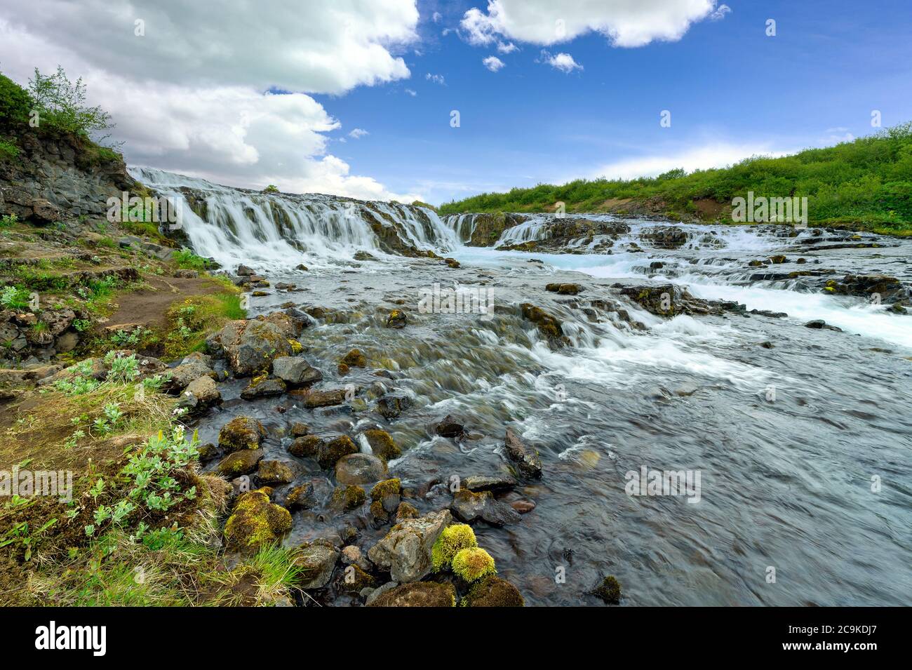 Der wunderschöne und erstaunliche bruarfoss Wasserfall in Island, der türkisfarbene Wasserbach. Grüne Bäume und blauer Himmel im Sommer ist hier ein versteckter Wasserfall Stockfoto