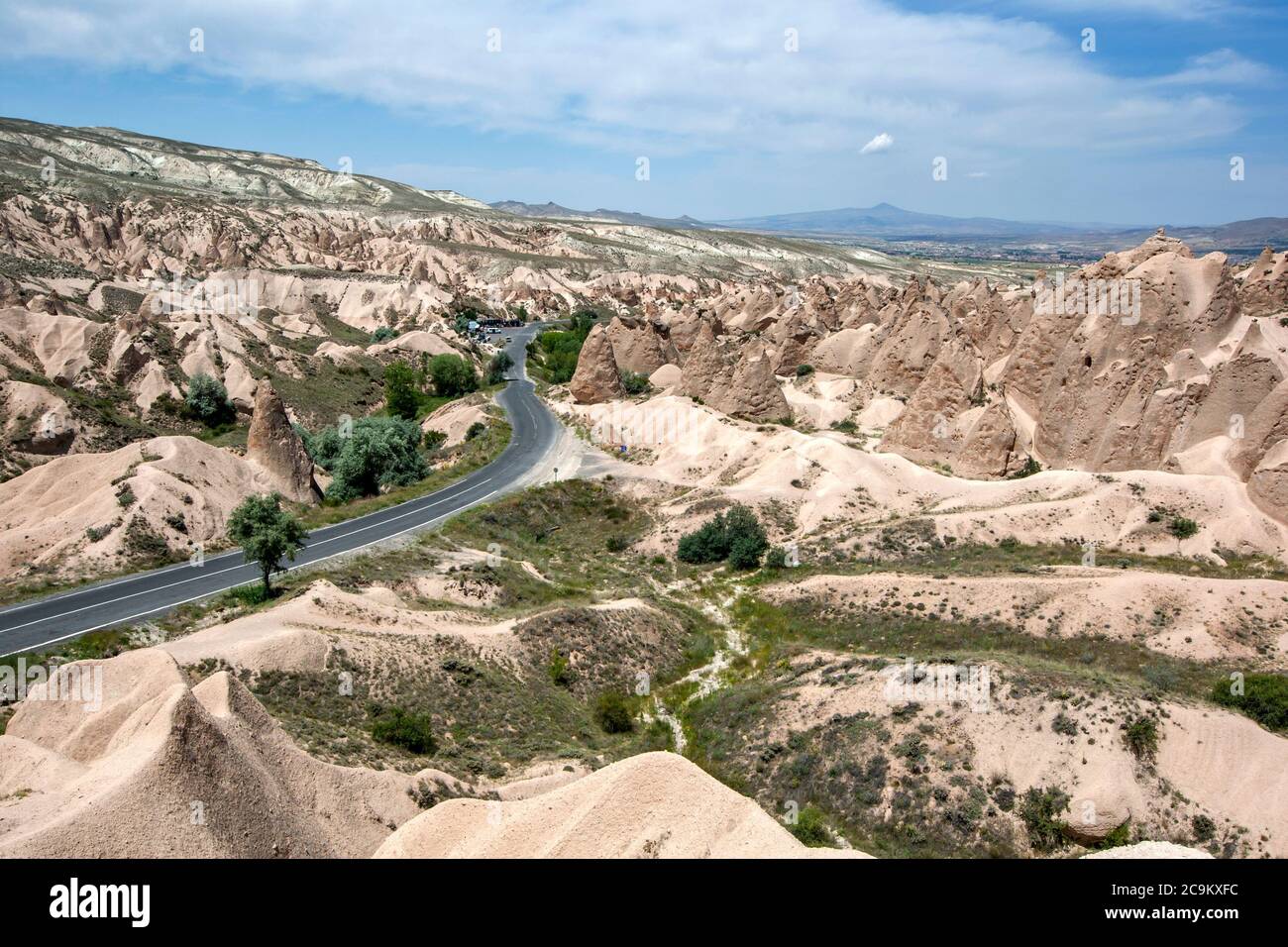 Eine Straße schlängelt sich durch die unglaublichen vulkanischen Felsformationen, die als Feenkamine im Devrent Valley in der Region Kappadokien in der Türkei bekannt sind. Stockfoto