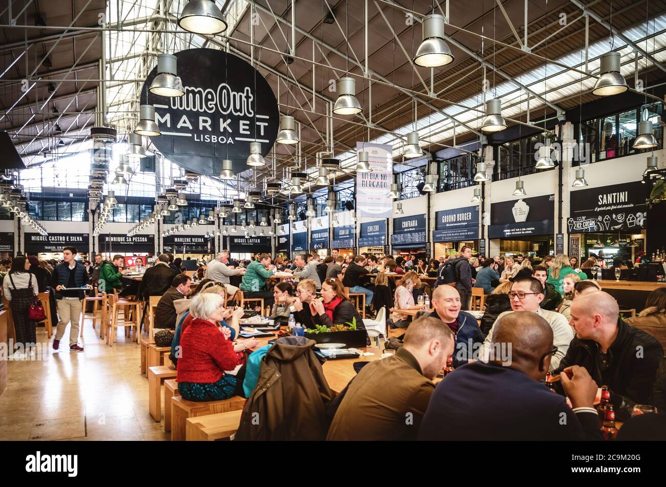 LISSABON, PORTUGAL - 3. FEBRUAR 2019: Menschen essen an den Tischen des Time Out Market, berühmtes traditionelles und Street Food Restaurant in Mercado da R Stockfoto