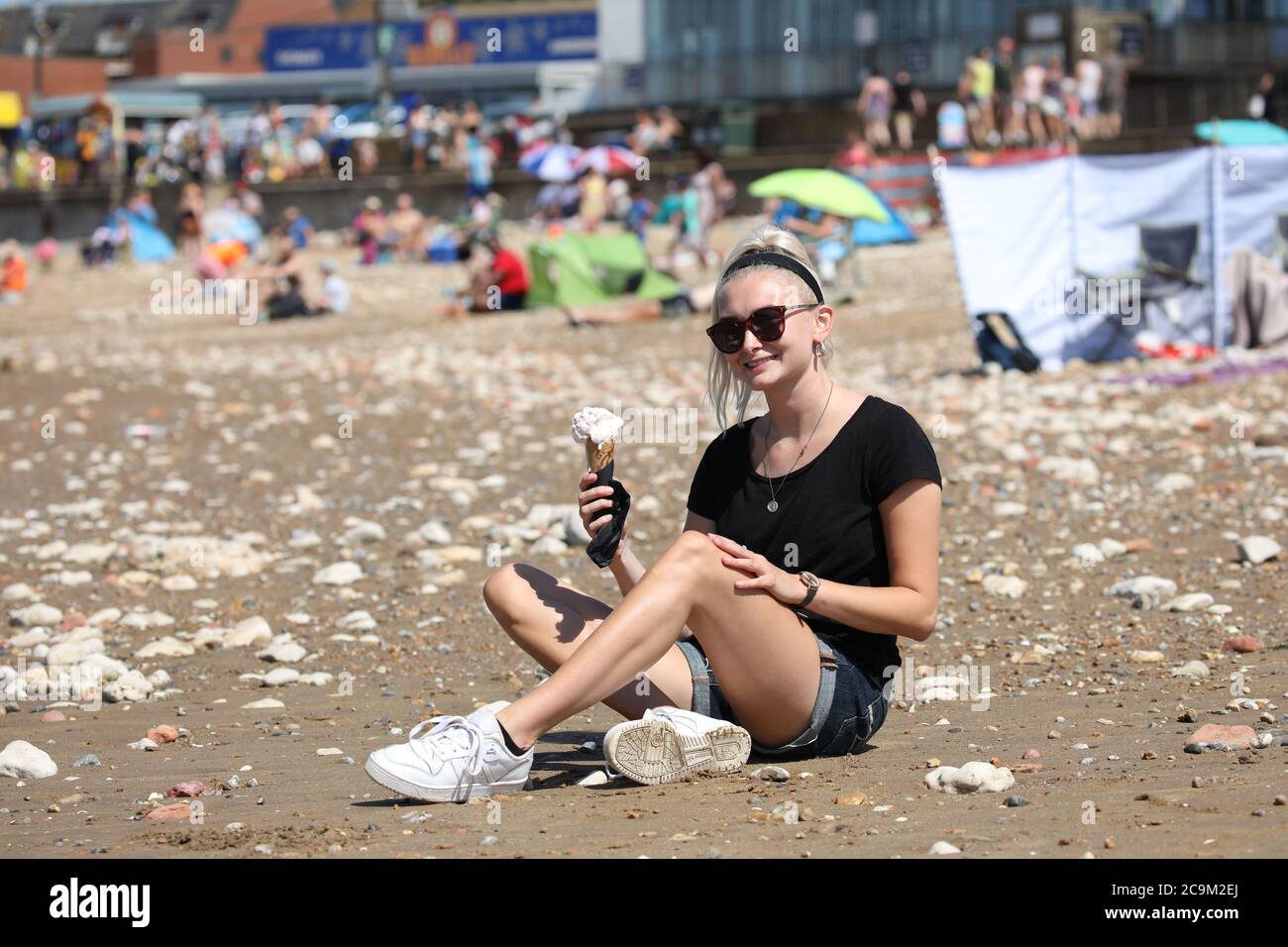 Hunstanton, Großbritannien. Juli 2020. Mia Wilkinson genießt ein Eis am heißesten Tag des Jahres wird heute erwartet, und es ist ein vielversprechender Start, wenn die Sonne scheint am Strand in Hunstanton, Norfolk. Kredit: Paul Marriott/Alamy Live Nachrichten Stockfoto