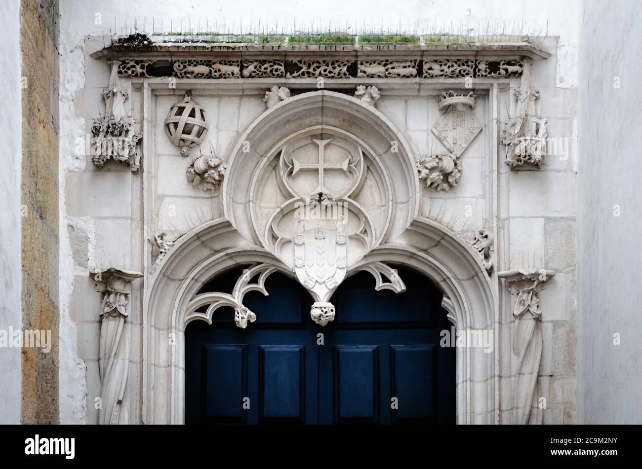 TOMAR, PORTUGAL - 31. JANUAR 2019: Seitentür der st. john Kirche in Tomar, Portugal, mit traditionellen heraldrischen portugiesischen Symbolen, am 31. januar Stockfoto