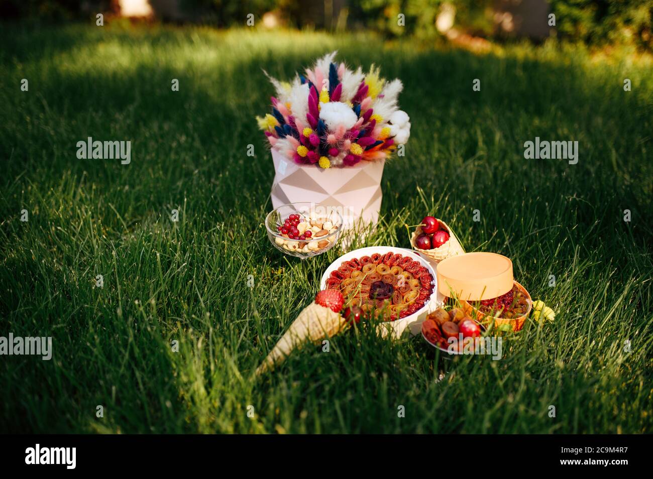Teeparty, Süßigkeiten, Berrie und Blumen auf dem Gras Stockfoto