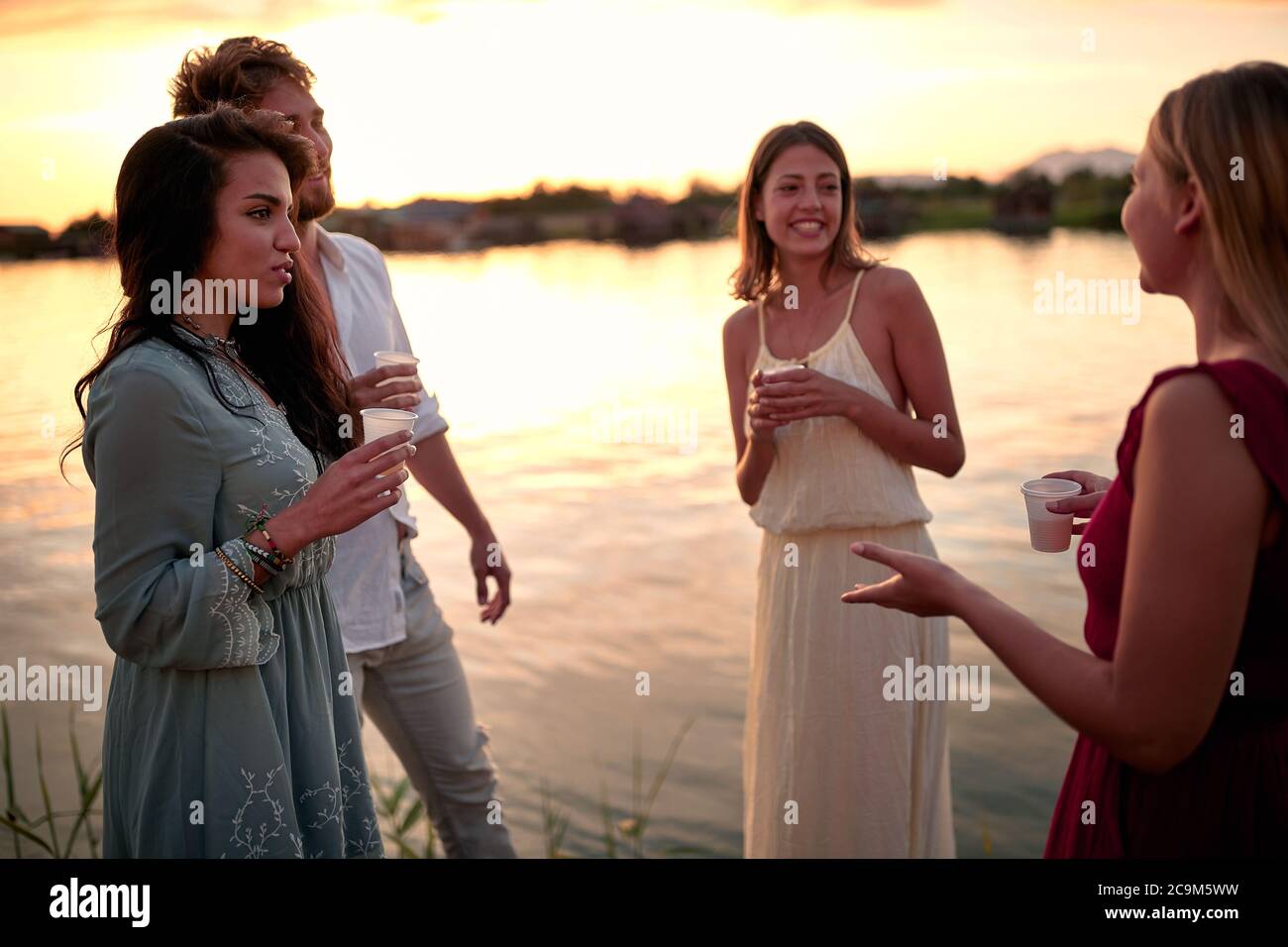 Freunde genießen bei Party.lächelnde Menschen trinken bei der Abendgesellschaft. Stockfoto