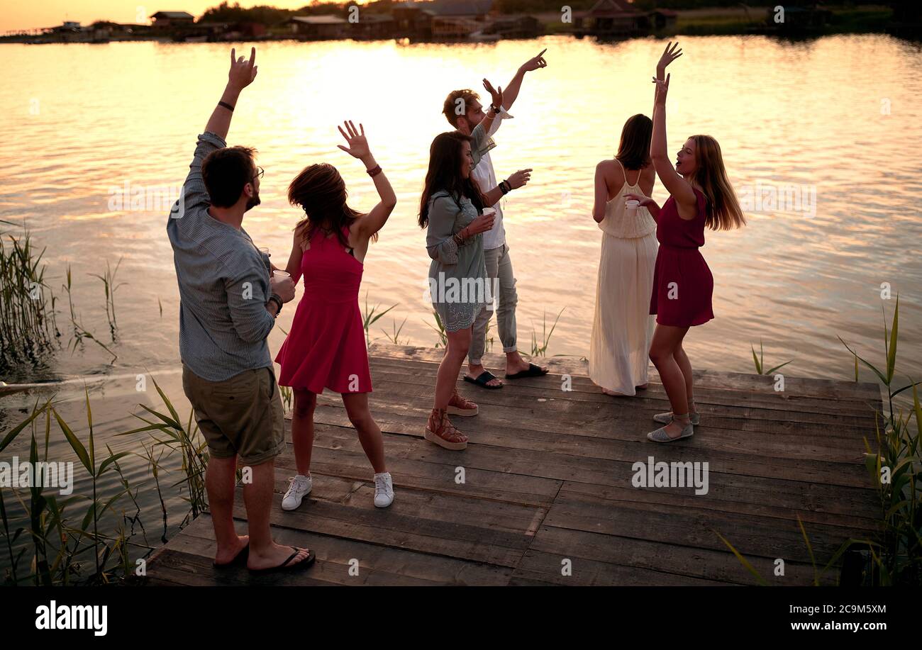 Party am Dock am Fluss am Abend. Glückliche Leute, die Spaß zusammen haben. Stockfoto