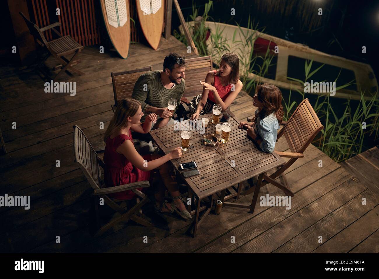 Lächelnde Menschen reden und trinken Bier und genießen einen schönen Abend. Stockfoto