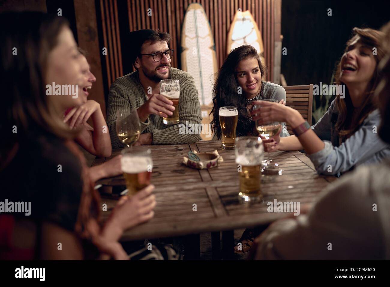 Freunde, die Spaß auf einer Party im Freien haben. Glückliche Menschen genießen Getränke zusammen. Stockfoto