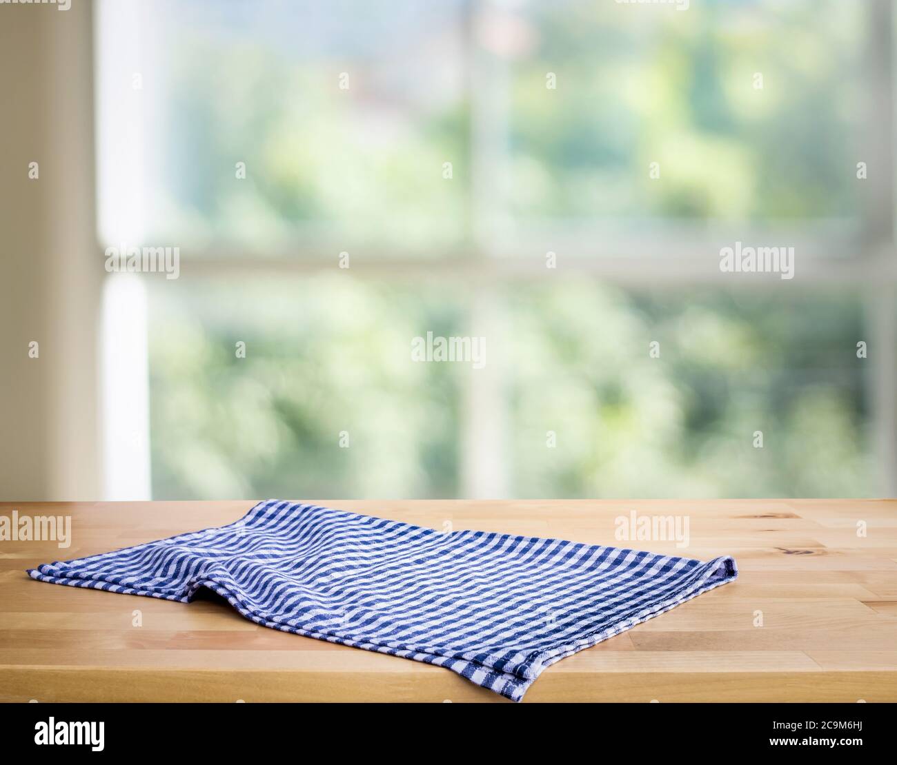 Blau karierte Tischdecke auf Holz mit Blur grünen Bokeh aus Fenster Küche Hintergrund.Sommer und Picknick-Konzepte.Design für wichtige visuelle Lebensmittel und Getränke p Stockfoto
