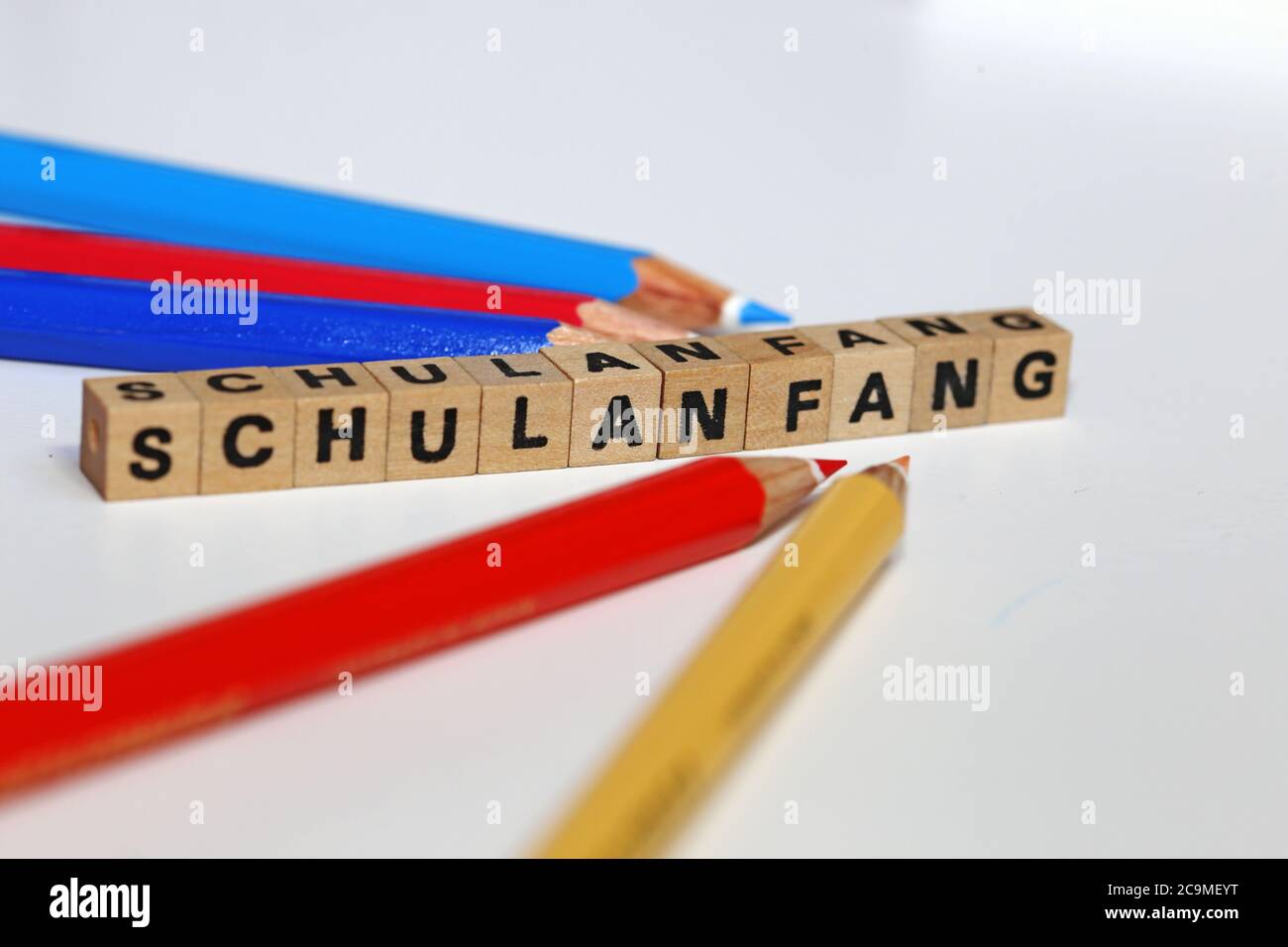 Symbolbild zum Beginn des neuen Schuljahres mit Buchstabenwürfel und Kugelschreibern Stockfoto