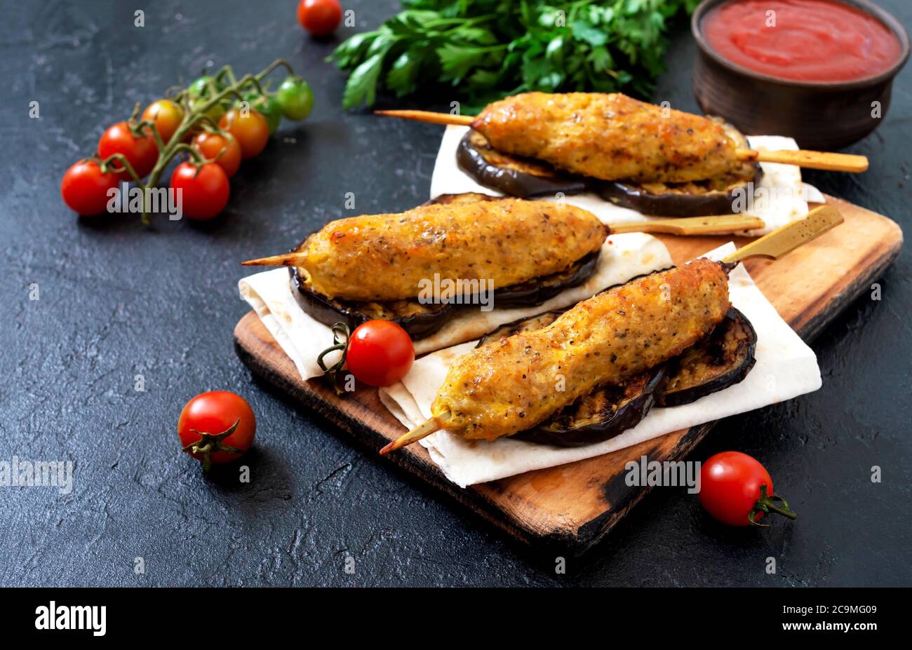 Lula Kebab mit gegrillter Aubergine auf Pita-Brot. Hähnchenkebabs auf einem Spieß mit Gemüse. Stockfoto