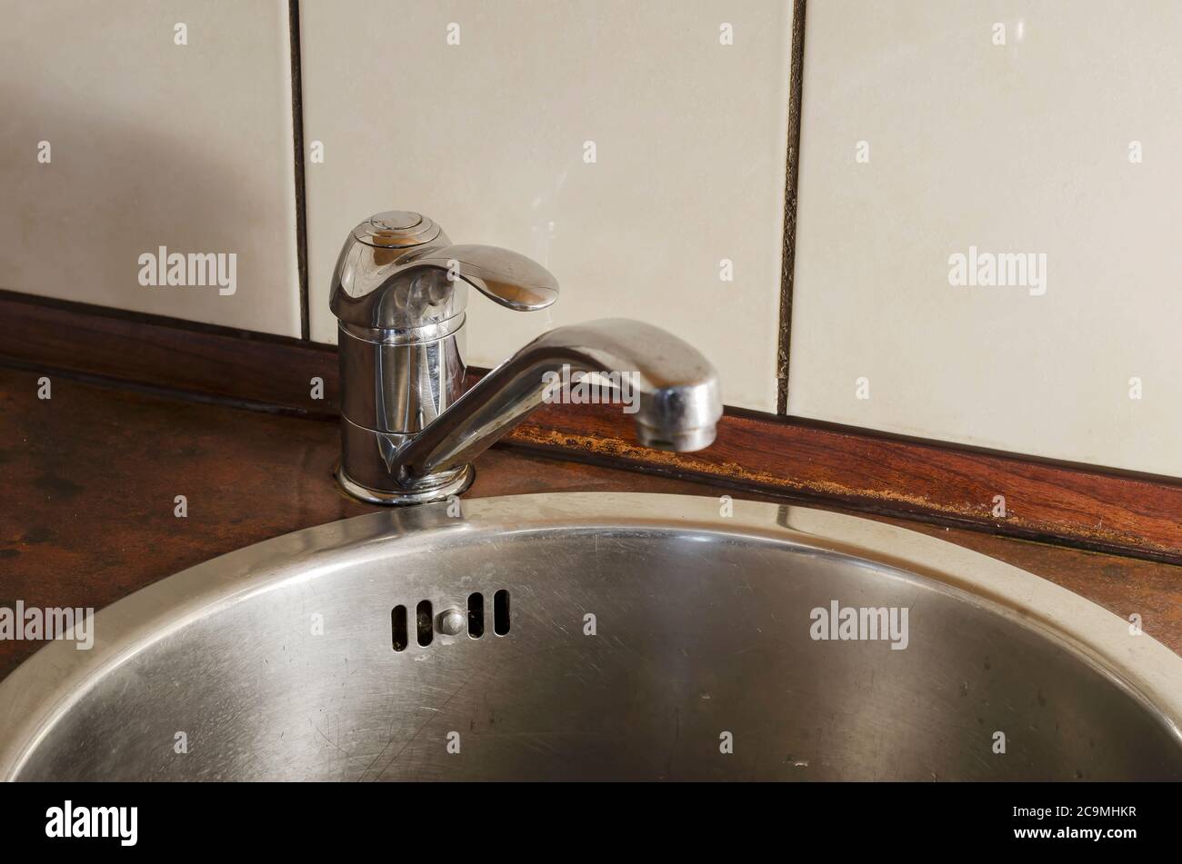 Rundes Küchenwaschbecken aus Edelstahl mit Mixer. Ansicht von oben in einem Winkel von Metall Waschbecken. Sanitäre Reinigung der Räumlichkeiten. Ohne jemanden. Stockfoto