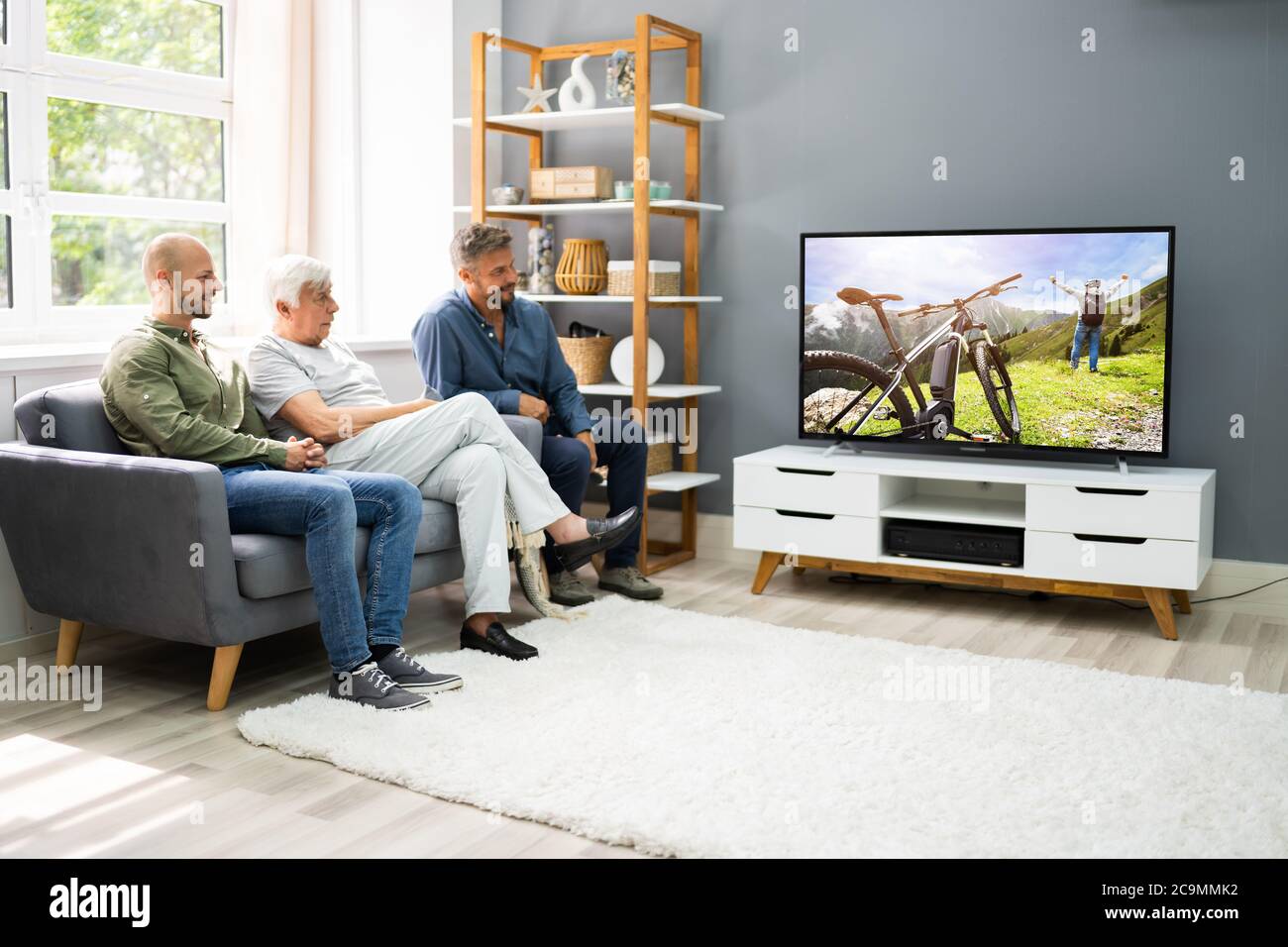 Familie, die im Wohnzimmer Fernsehen mit Großeltern Stockfoto