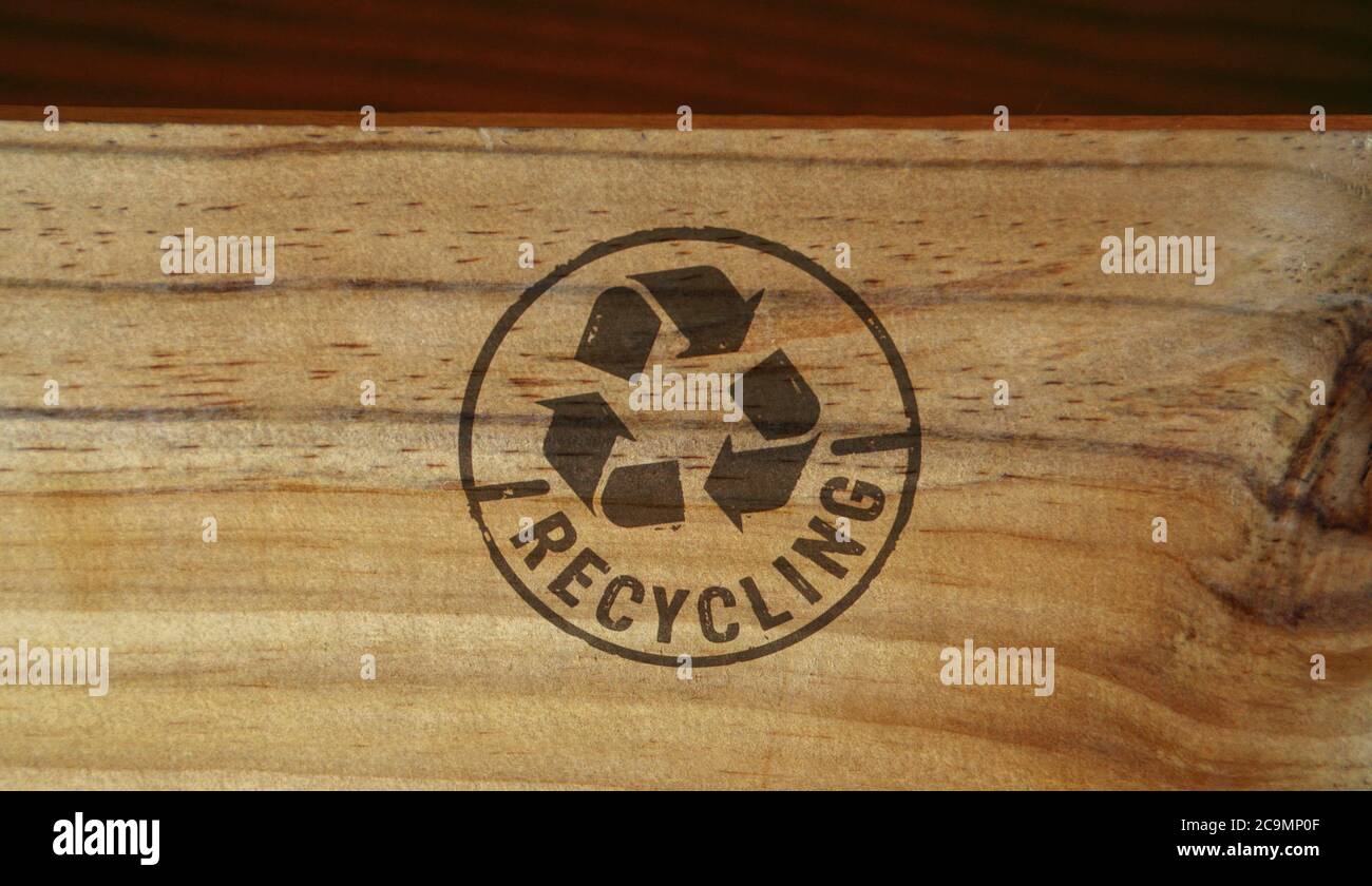 Recyclingstempel auf Holzkiste aufgedruckt. Recycling-Symbol, Pfeile, wiederverwertbare Materialien, Umweltschutz und erdsicheres Konzept. Stockfoto