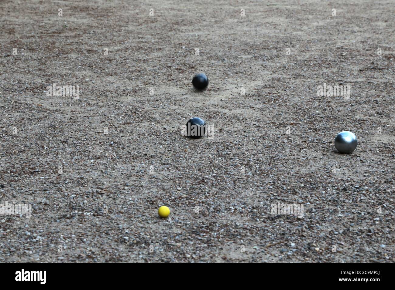 Boule und kleiner gelber Bube auf dem Boule-Feld, Stockfoto