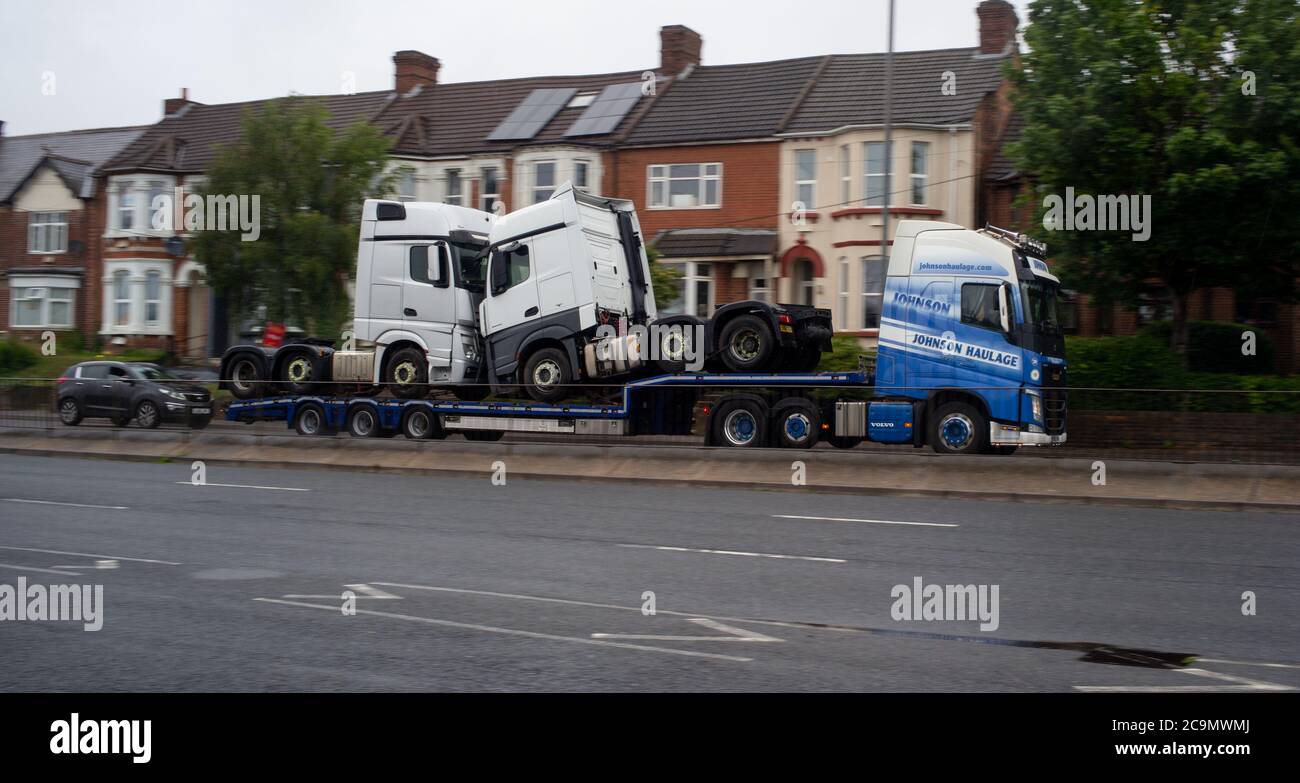 Ein Johnson-Transporter mit zwei LKWs auf Anhänger, der auf der Millbrook Road Southampton in Richtung Southampton Docks fährt. Stockfoto