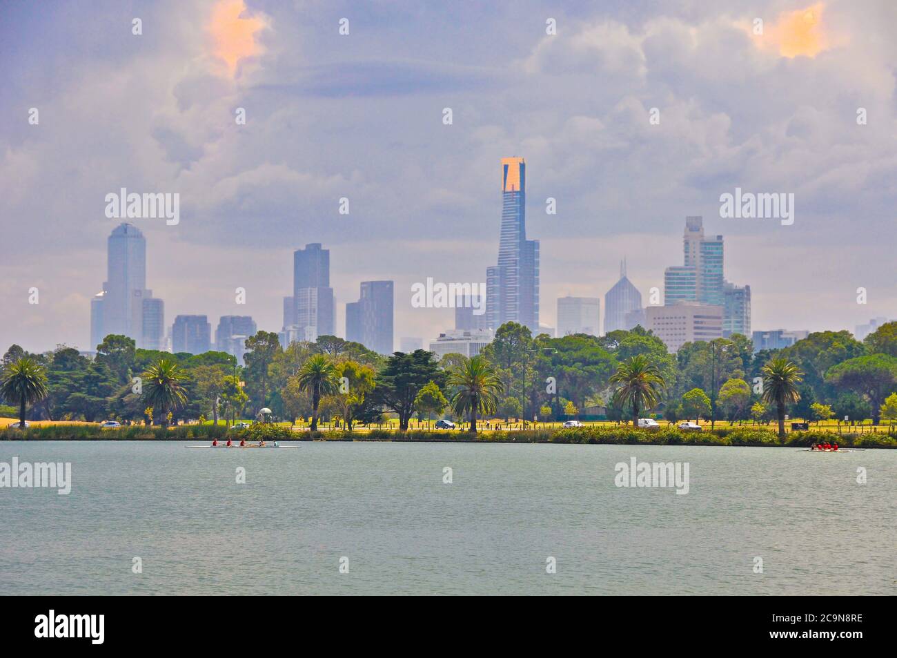 Die Skyline von Melbourne unter sich aufziehenden Sturmwolken mit dem Albert Park Lake im Vordergrund und dem Eureka Skydeck 88 Gebäude im Vordergrund. Stockfoto