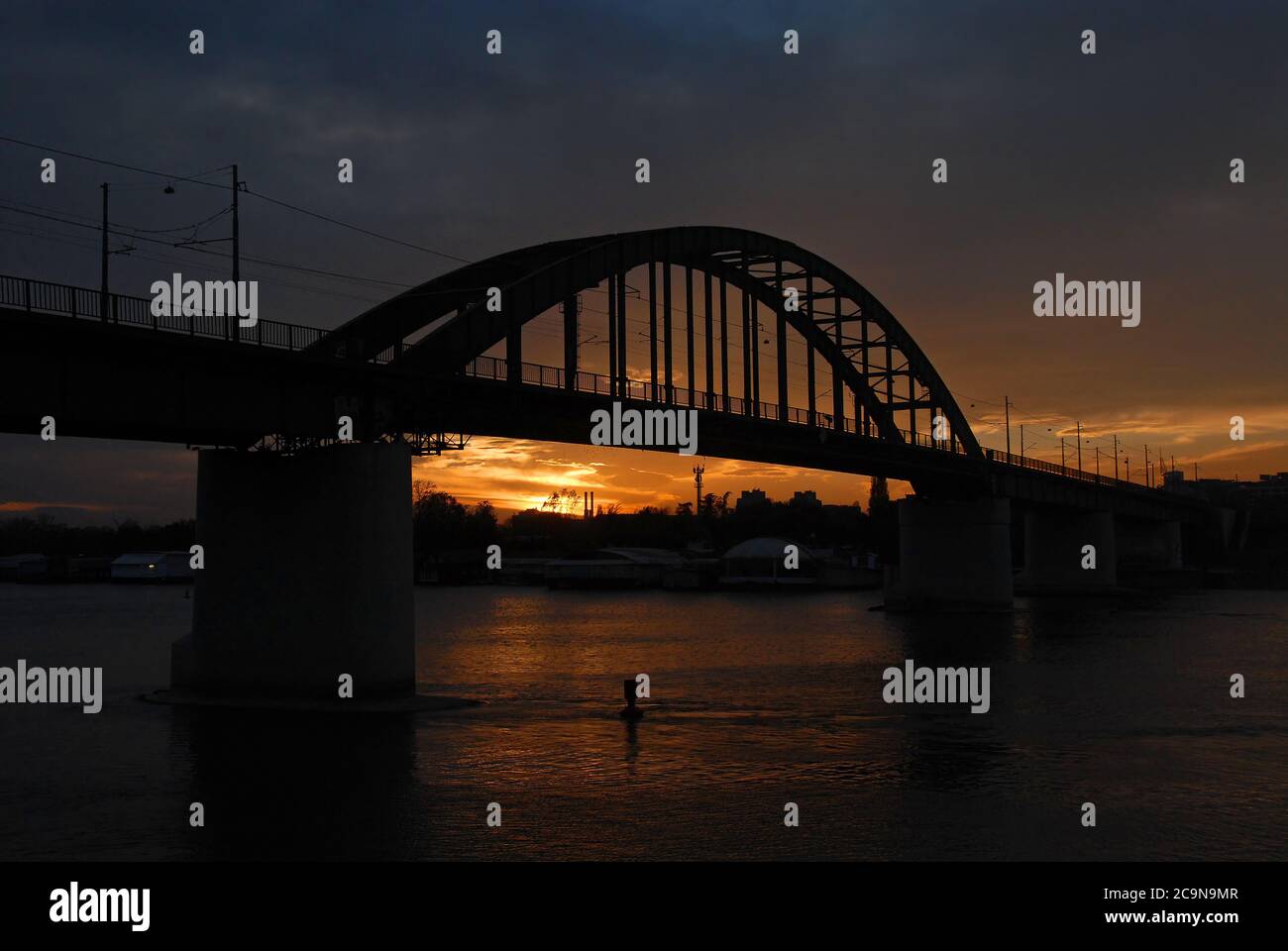 Die Old Sava Bridge bei Sonnenuntergang in Belgrad, Serbien. Die Brücke überquert die Sava im Zentrum von Belgrad und ist vom orangefarbenen Himmel abgeschirmt Stockfoto