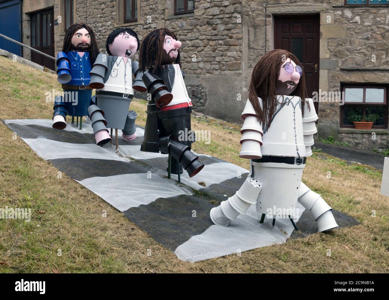 Settle, North Yorkshire, Großbritannien. 1. August 2020: Das jährliche Flowerpot Festival wird in Settle, North Yorkshire, UK eröffnet. Topische Blumentopf-Figuren. Entworfen und von Anwohnern gemacht, erscheinen rund um die Yorkshire Marktstadt im August. Gezeigt werden die Beatles, die über die Zebrakreuzung der Abbey Road laufen, vom berühmten Abbey Road Albumcover. Diese besondere Ausstellung wurde von ortsansässigen Richard Handscombe gemacht. Quelle: John Bentley/Alamy Live News Stockfoto