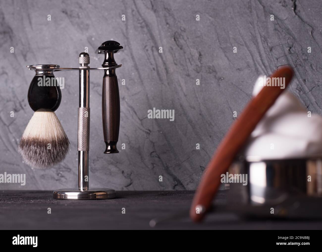 Rasiermesser, Pinsel und Parfüm auf einem Holzhintergrund. Stockfoto