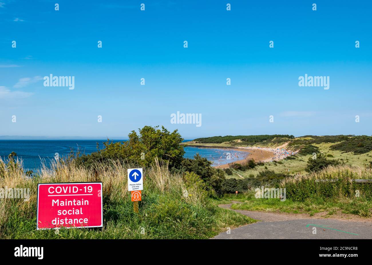 Überfüllter Strand mit sozialer Distanz und Einbahnschildern am heißen Sommertag während der Covid-19 Pandemie, Gullane, East Lothian, Schottland, Großbritannien Stockfoto