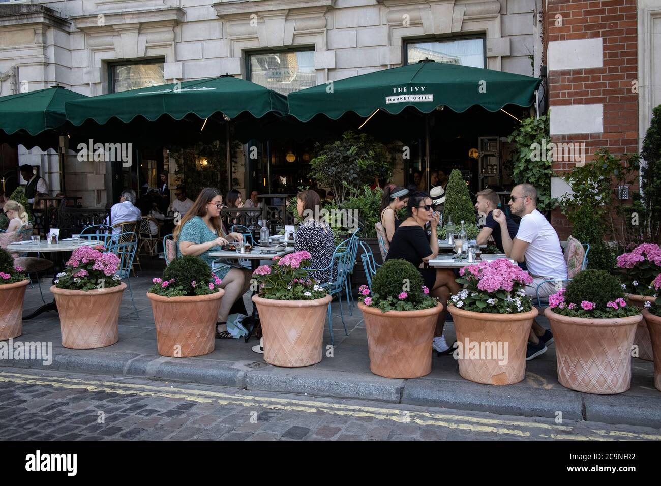 Leute saßen draußen beim Essen im Ivy, Henrietta Street, Covent Garden, London WC2 nach der Coronavirus-Sperre, Großbritannien Stockfoto