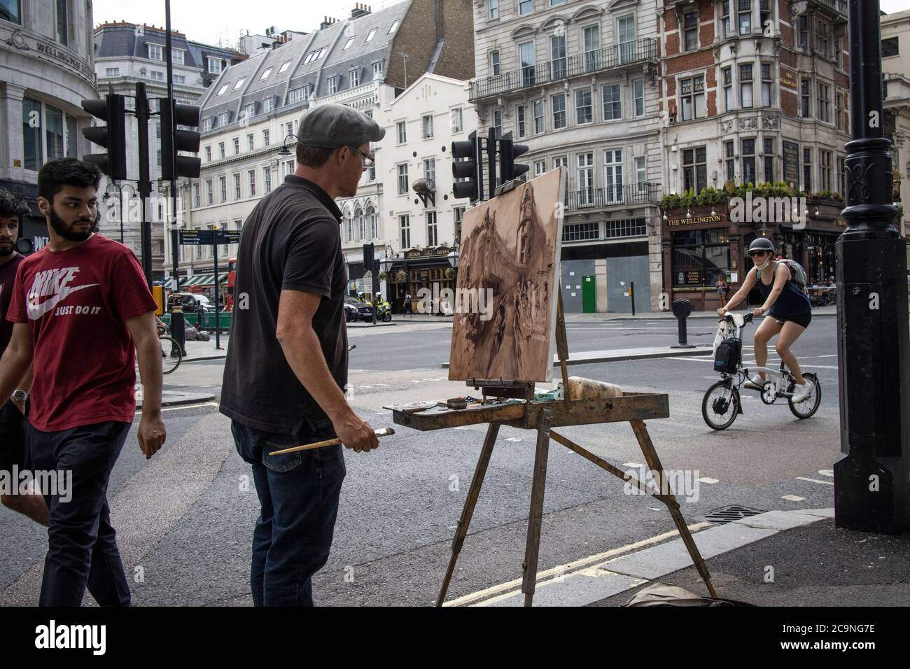 Straßenkünstler, der auf Leinwand die Ecke Wellington Street und Stran, Central London, England, Großbritannien, einfängt Stockfoto